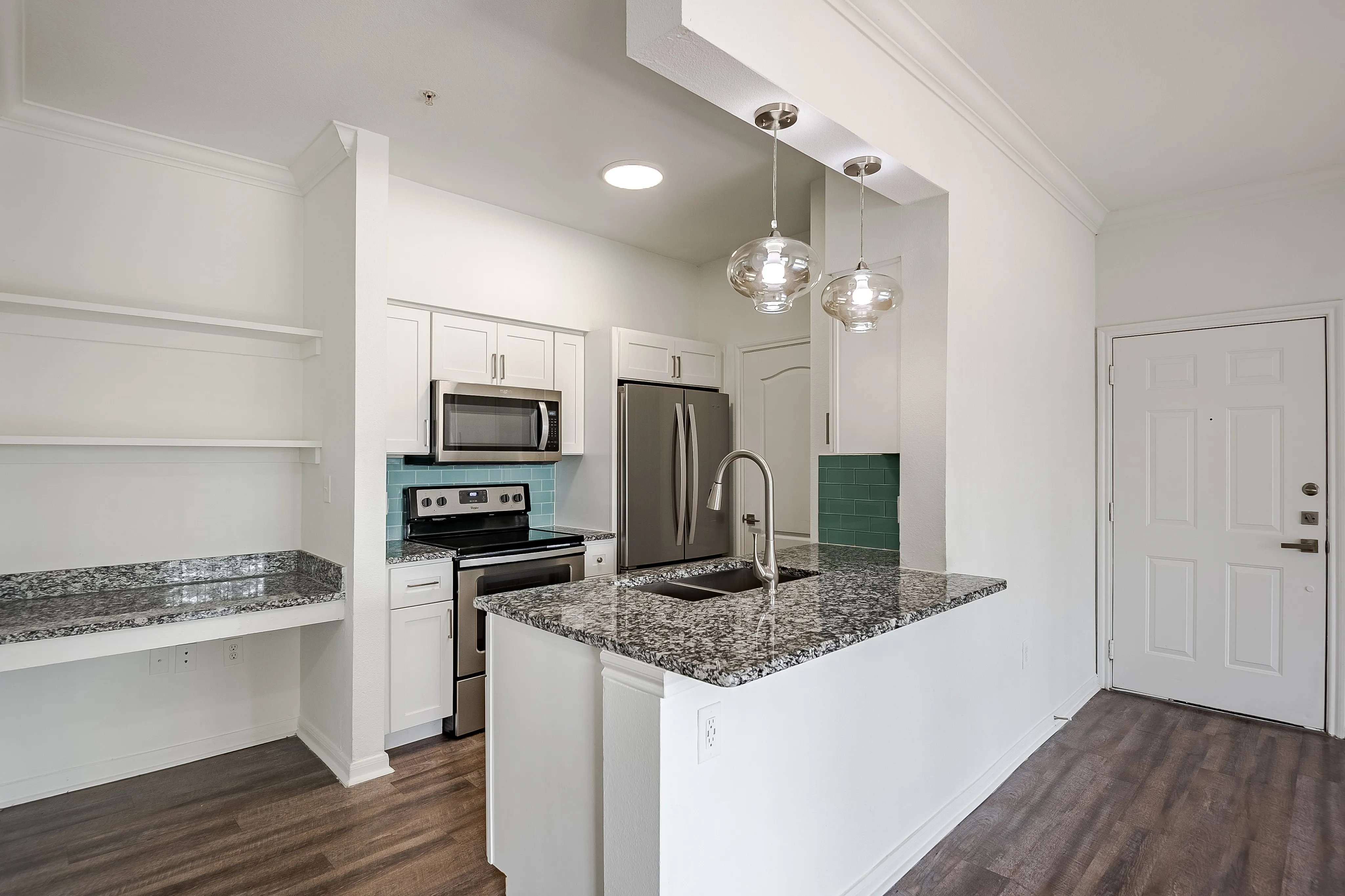 Modern kitchen with sleek granite countertops, stainless steel appliances, and stylish pendant lighting, perfect for culinary enthusiasts.