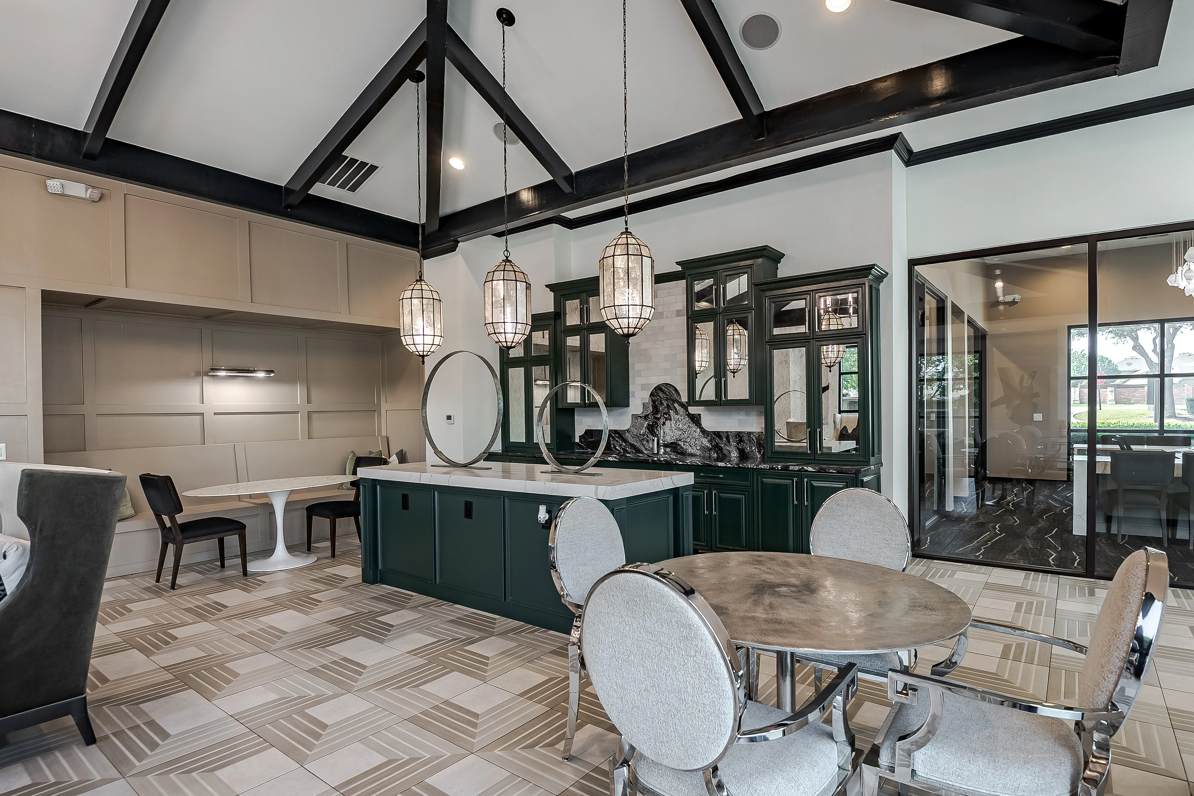Elegant contemporary kitchen with vaulted ceilings, sleek pendant lighting, green cabinetry, and a chic dining area.
