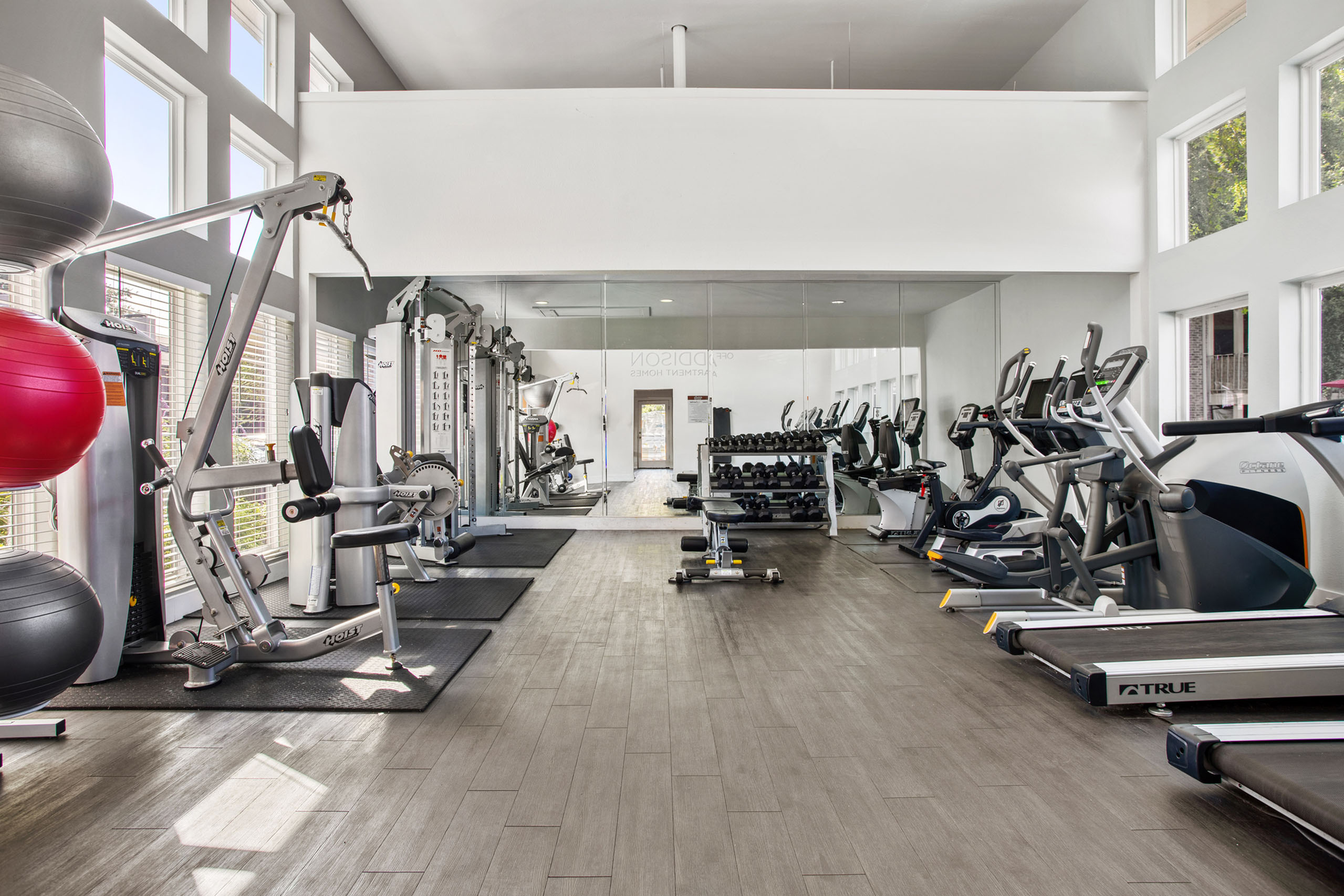 Modern fitness center featuring state-of-the-art exercise equipment, bright windows, and sleek flooring.