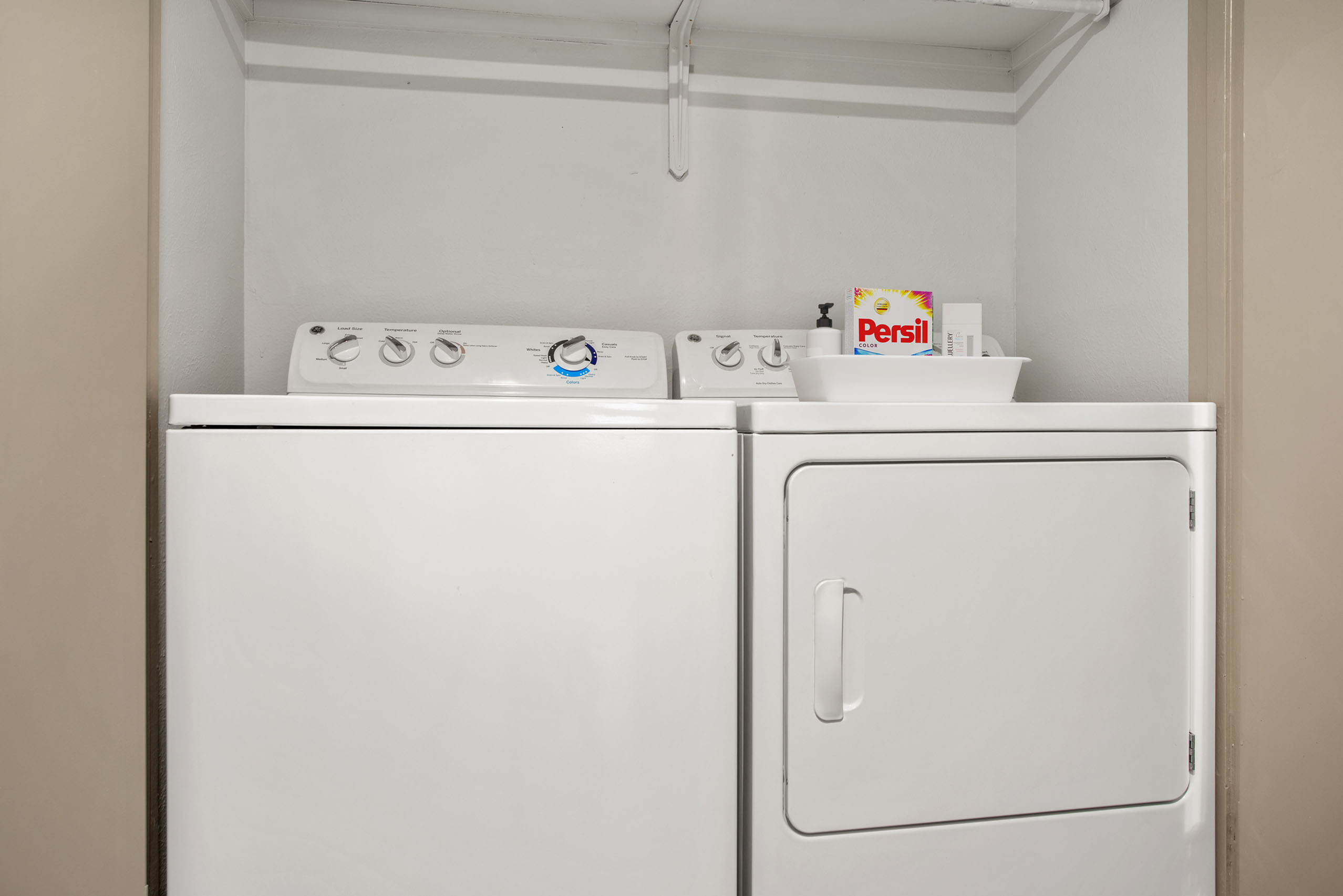 Modern laundry room with efficient washer and dryer set, complemented by convenient shelving.