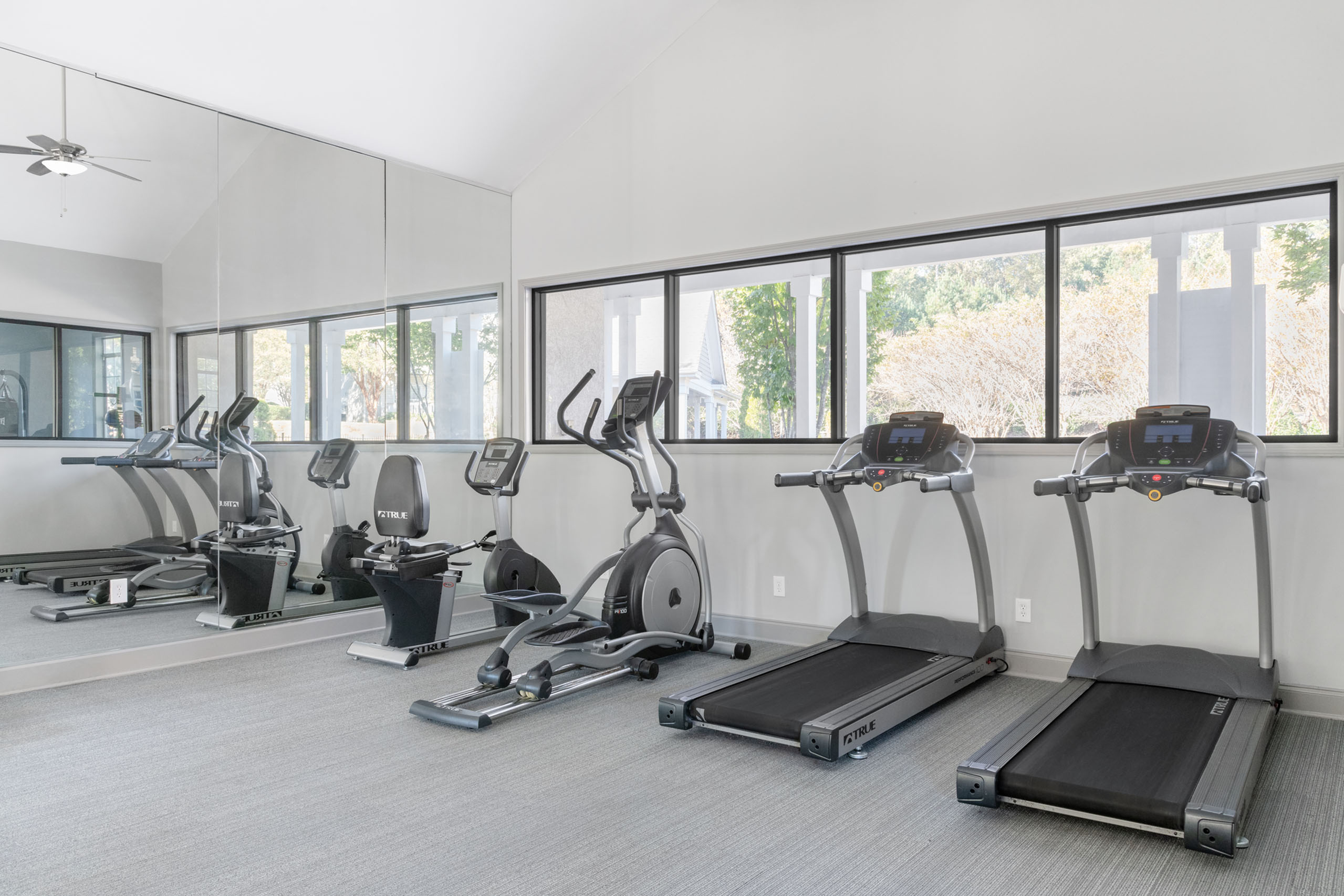 Modern fitness center featuring state-of-the-art treadmills, stationary bikes, and mirrored walls offering a bright, invigorating space.