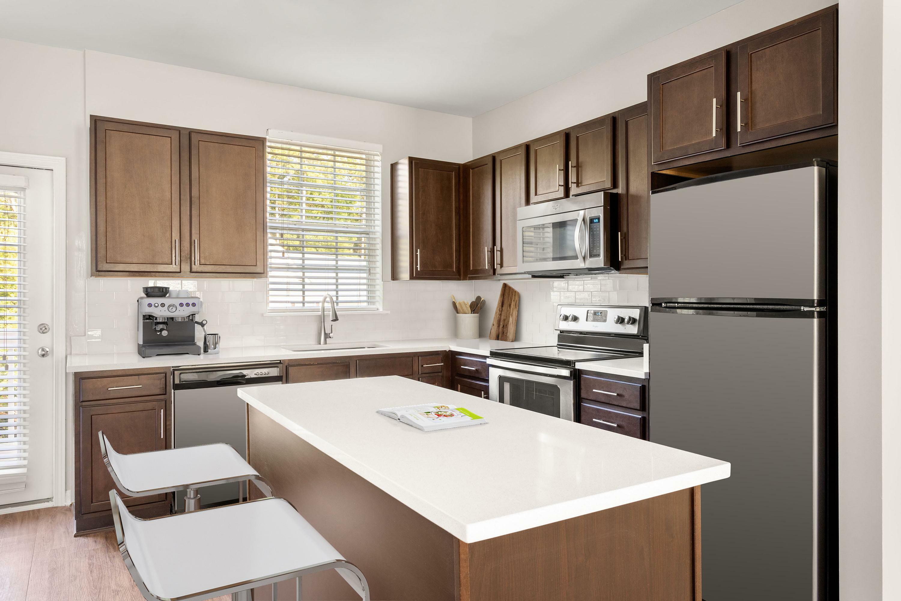 Contemporary kitchen design with sleek stainless steel appliances, rich wooden cabinets, and a bright island workspace, perfect for culinary creativity.