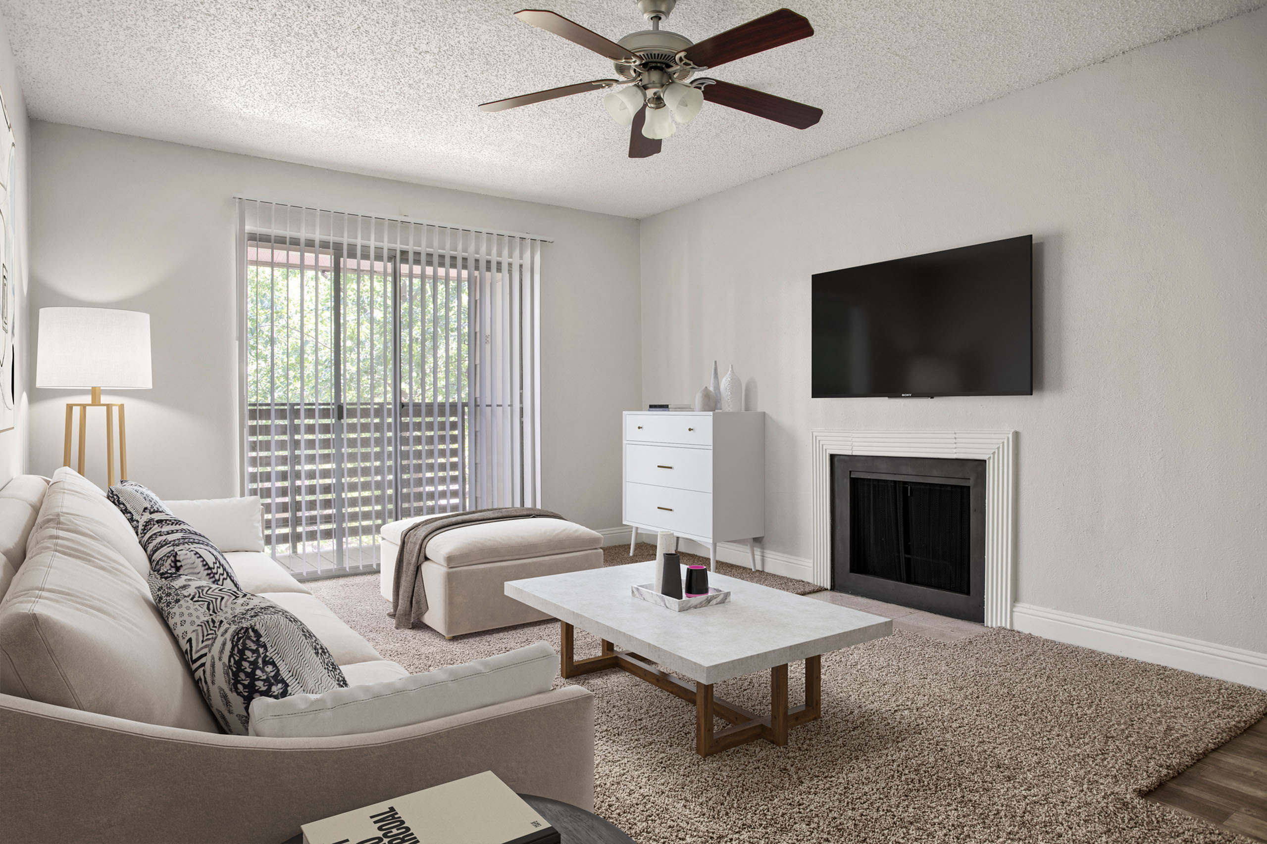 Bright and modern living room featuring a cozy sofa, sleek coffee table, and a stylish fireplace with a mounted TV, complemented by natural light streaming through floor-to-ceiling windows.
