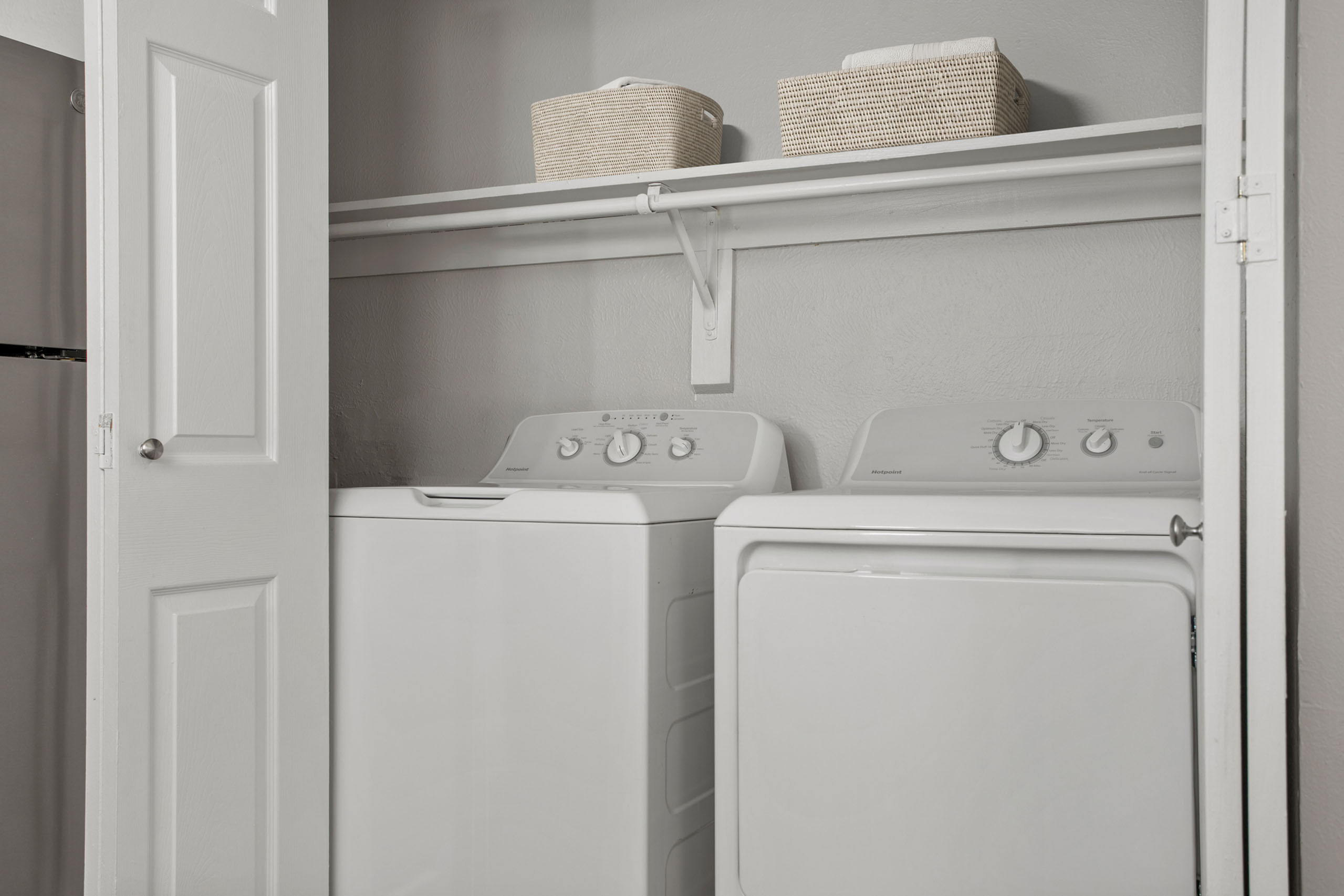 Modern laundry area featuring a high-efficiency washer and dryer, complemented by stylish storage solutions in a sleek, minimalistic design.
