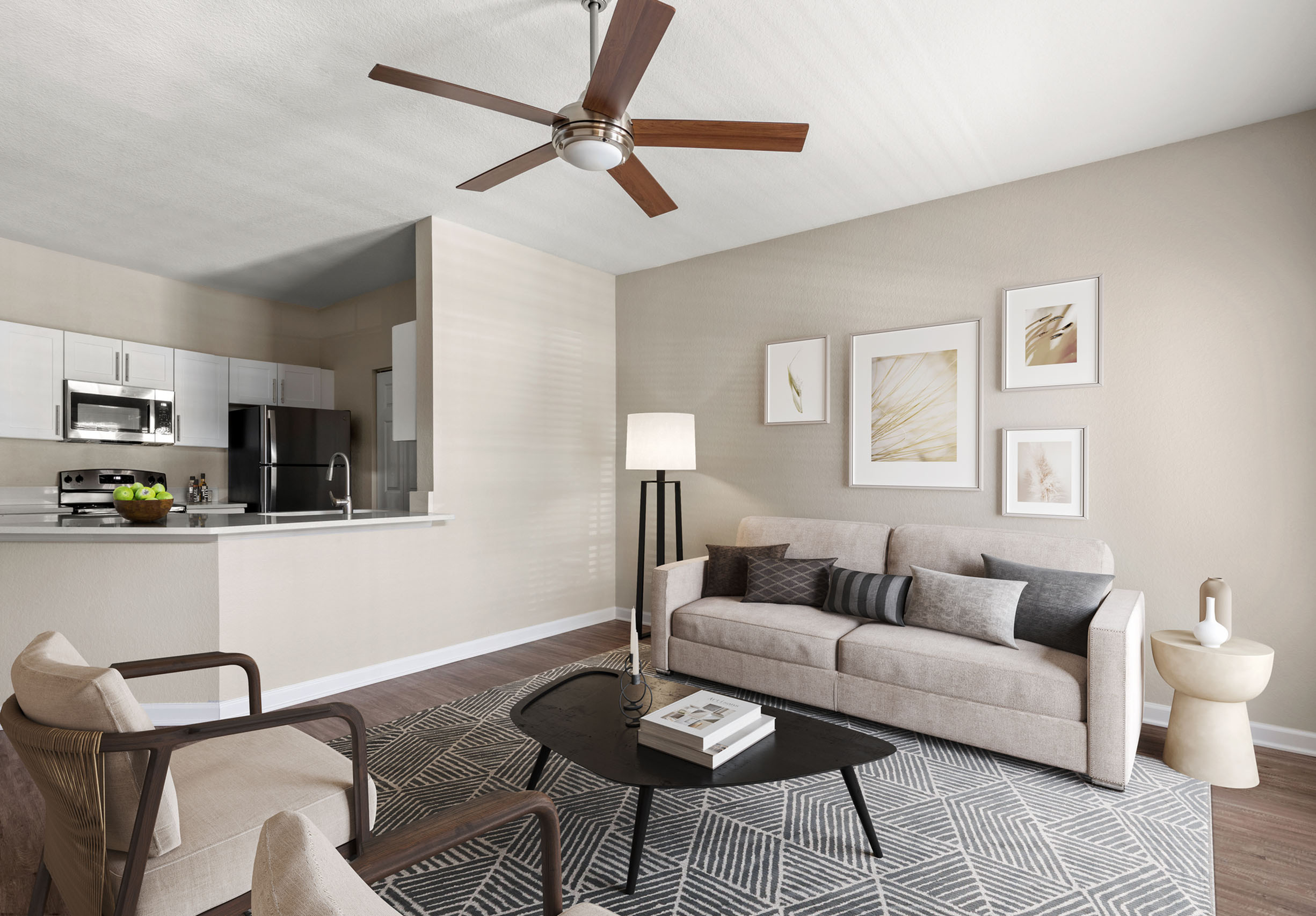 Modern apartment living room with a cozy beige couch, chic armchairs, and elegant decor, all complemented by a stylish open kitchen with sleek appliances.