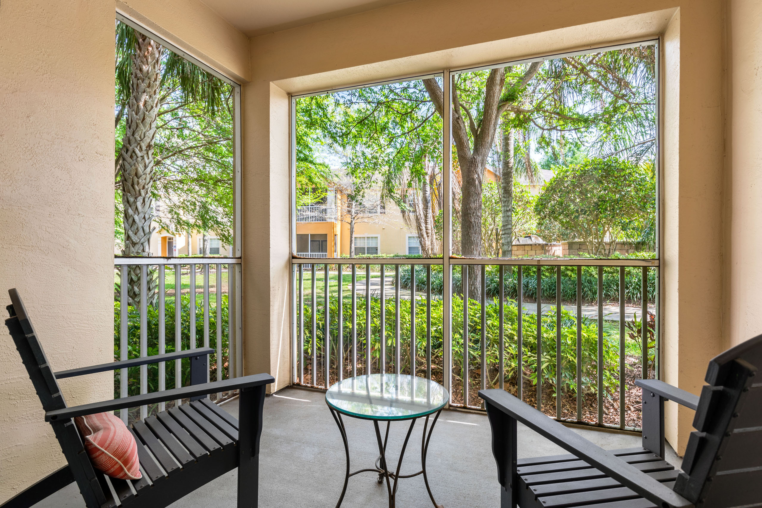 Charming patio with serene garden view, featuring comfortable seating and lush greenery.
