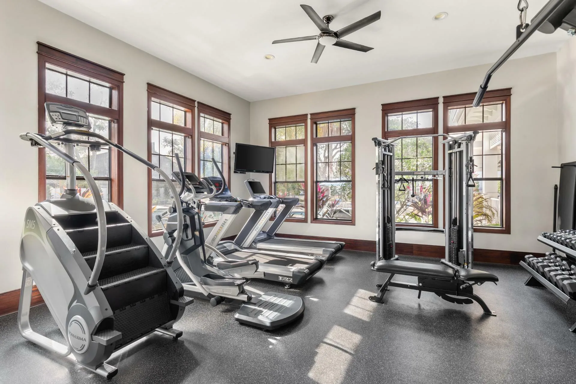 Modern apartment gym boasting state-of-the-art treadmills, exercise machines, and abundant natural light for an invigorating workout experience.