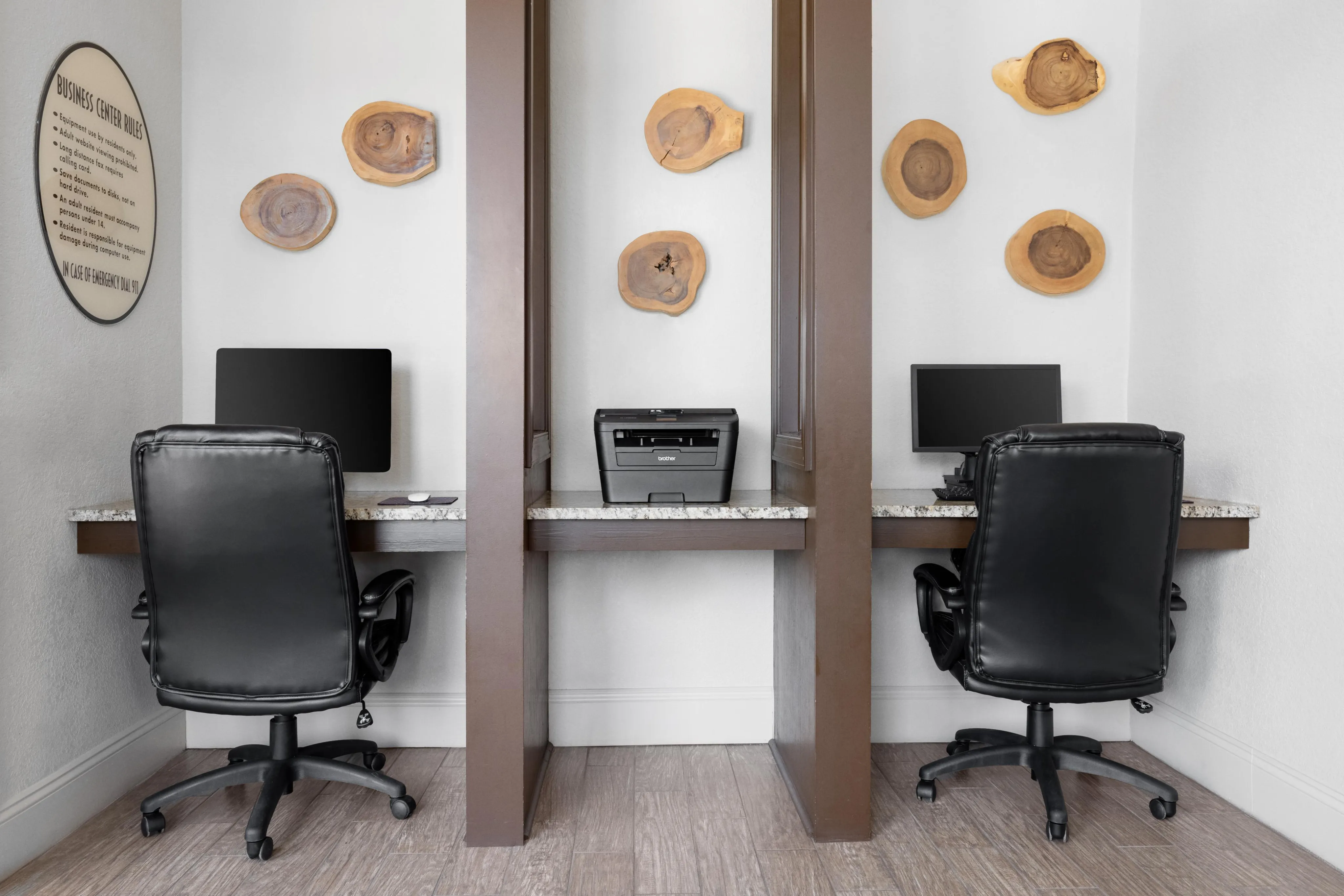 Modern business center with sleek workstations, cozy leather chairs, and artistic woodwork wall decor.