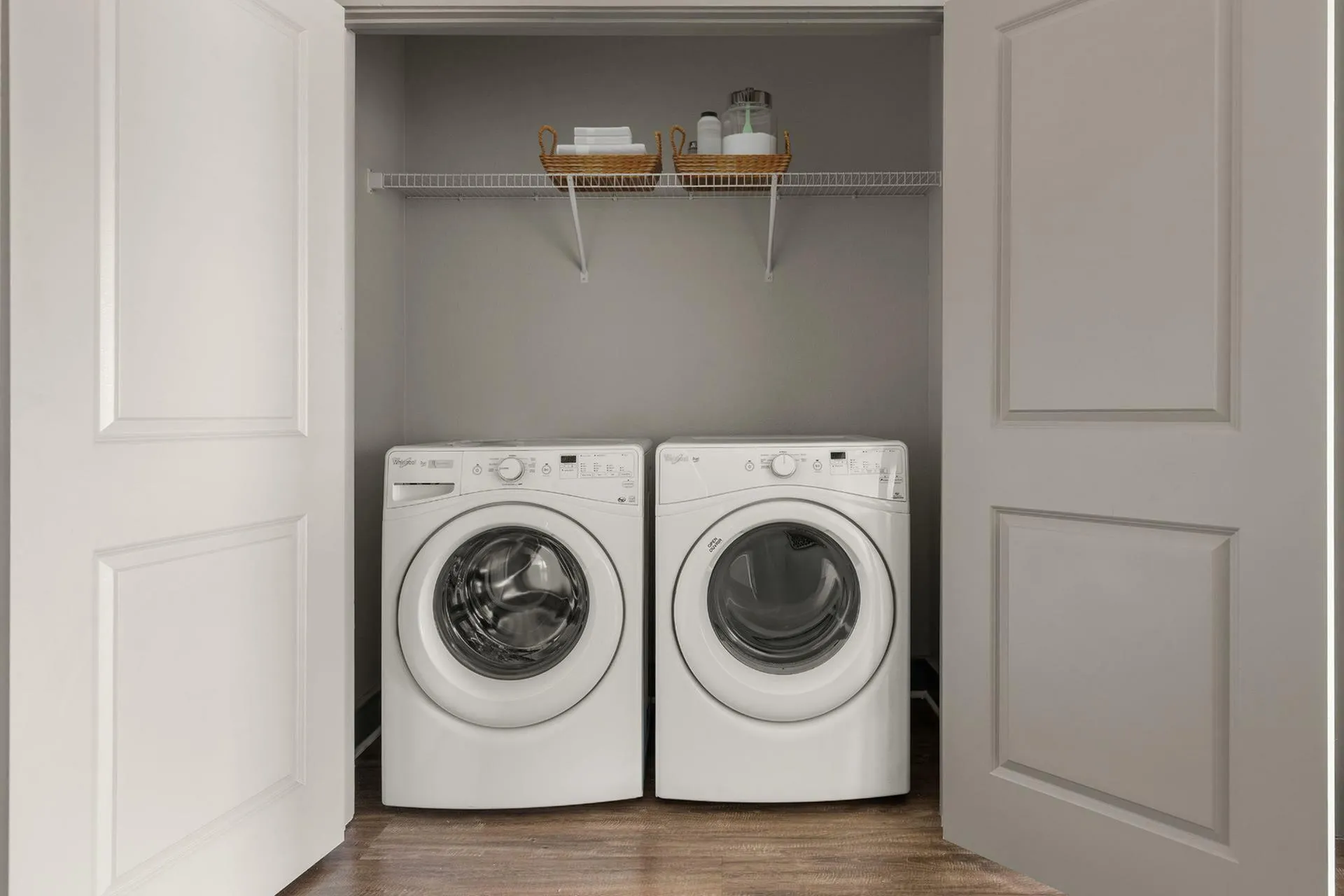 Convenient in-unit laundry closet with modern washer and dryer, featuring extra shelving for storage and organization.