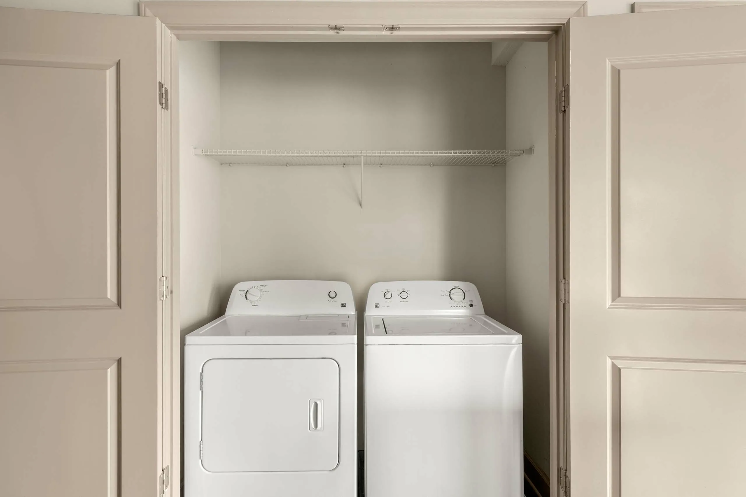Modern laundry area with pristine washer and dryer set, optimally fitted in a sleek closet space.
