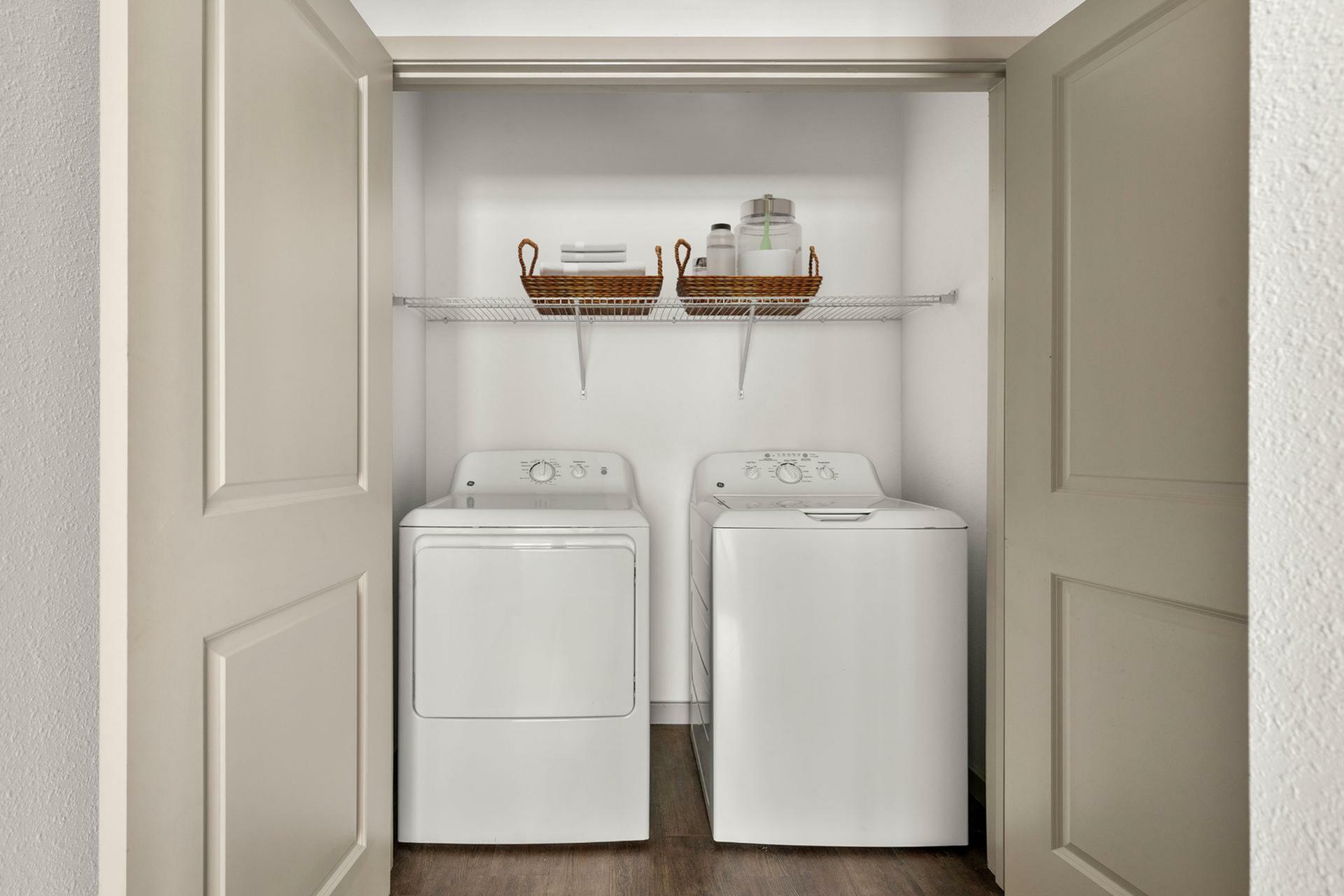 Modern in-unit laundry with washer and dryer, featuring chic shelving for organized convenience.
