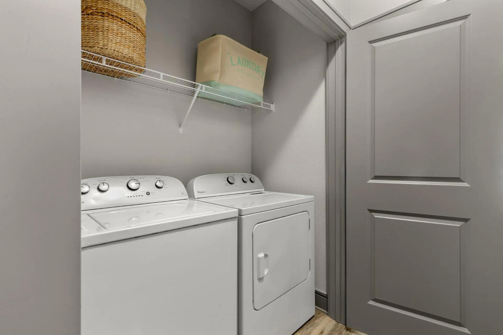 Modern laundry room featuring a sleek washer and dryer set, with stylish shelving for organization.