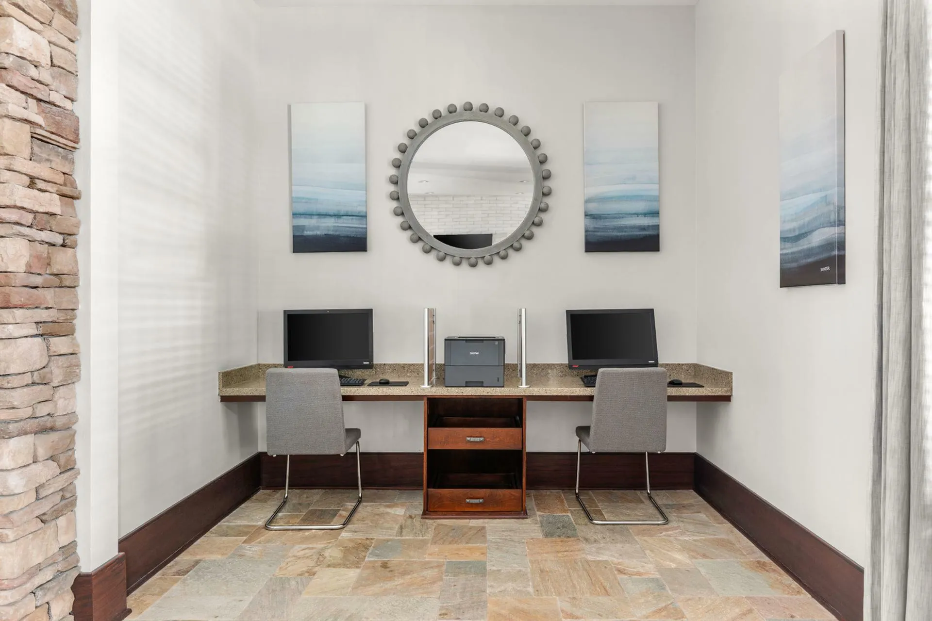 Chic shared office space with two computer stations, modern decor, and elegant artwork for a productive work environment.