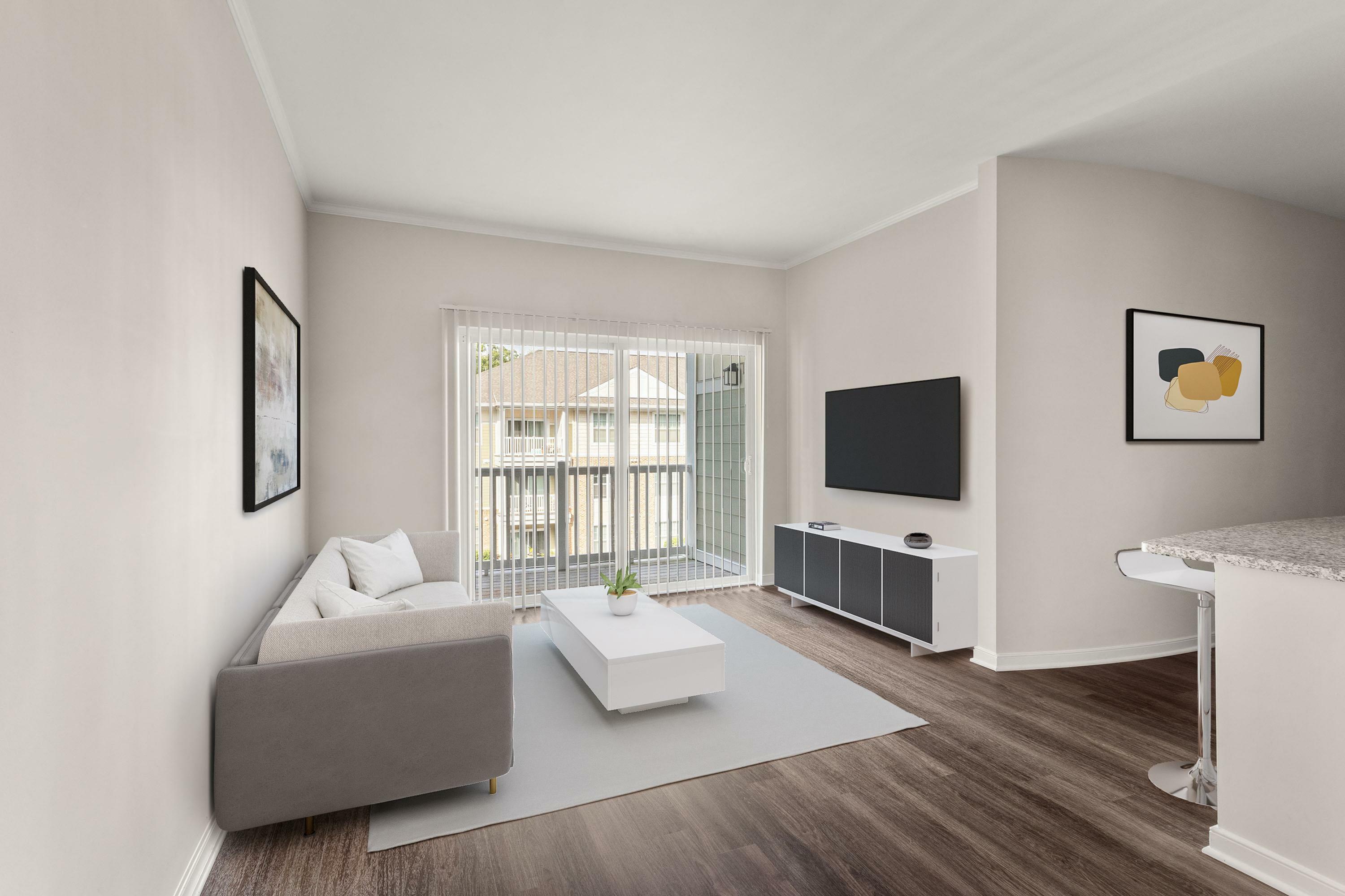 Modern living room with a sleek gray sofa, stylish coffee table, and large TV, opening to a bright balcony for natural light and fresh air.
