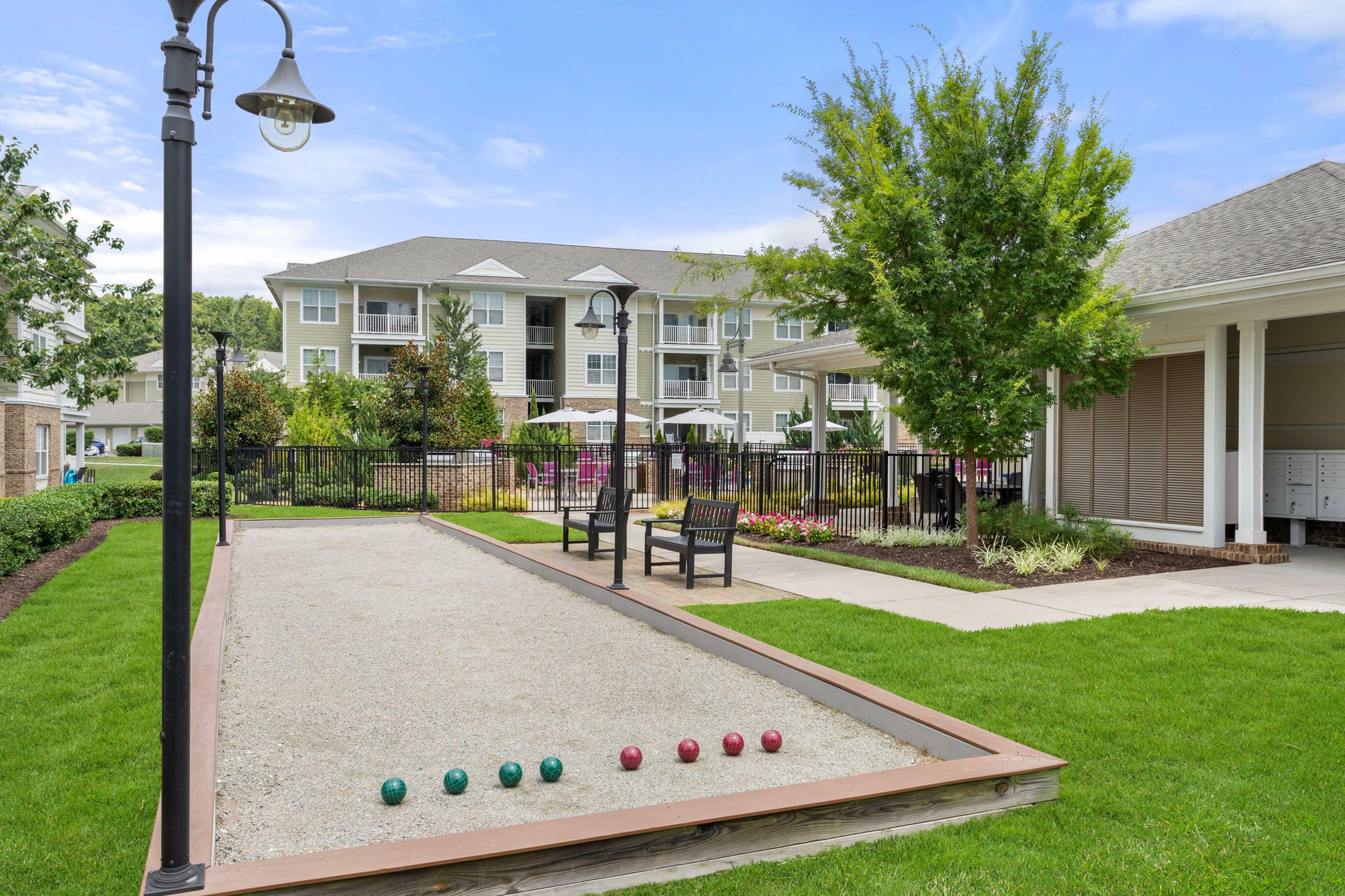 Charming apartment complex with lush gardens and a well-maintained bocce court, perfect for outdoor relaxation and fun.