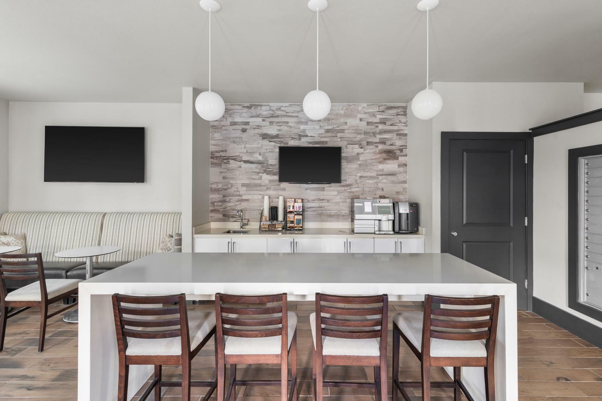 Modern communal space featuring sleek countertops, elegant bar stools, and a cozy seating area for gatherings.