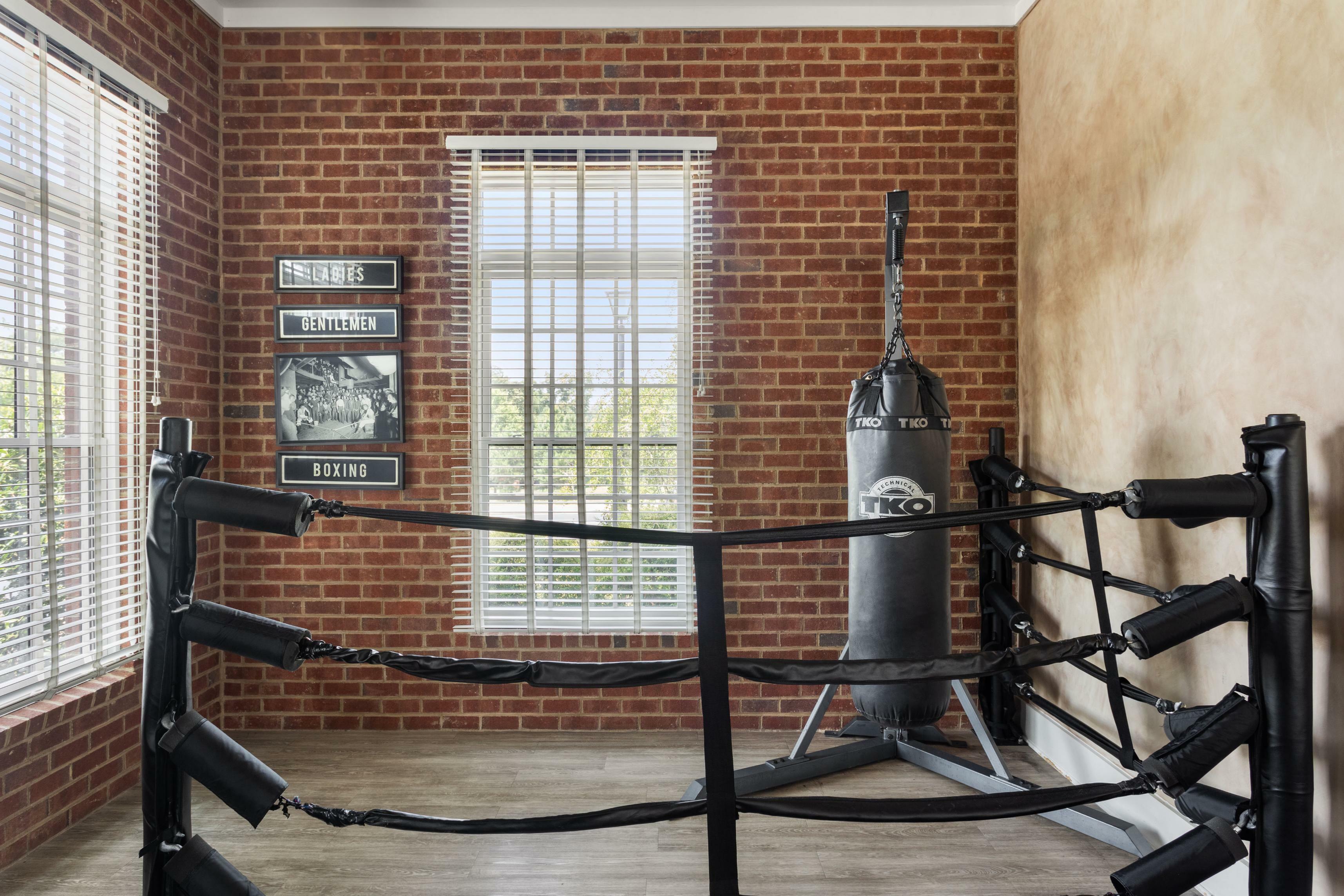 Chic home boxing gym with a vintage vibe, featuring a red brick wall, stylish decor, and a professional punching bag.