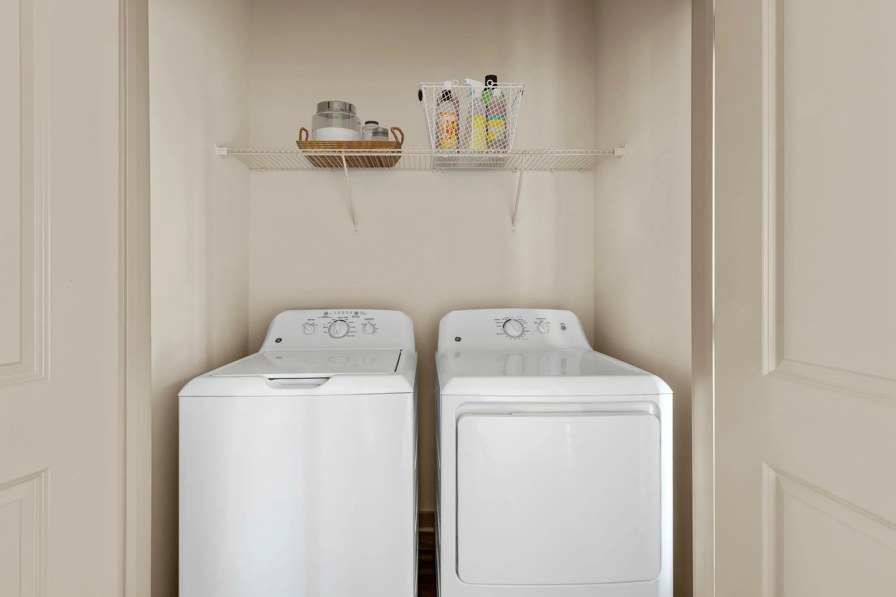 Modern laundry area with energy-efficient washer and dryer, complemented by ample storage shelving for convenience.