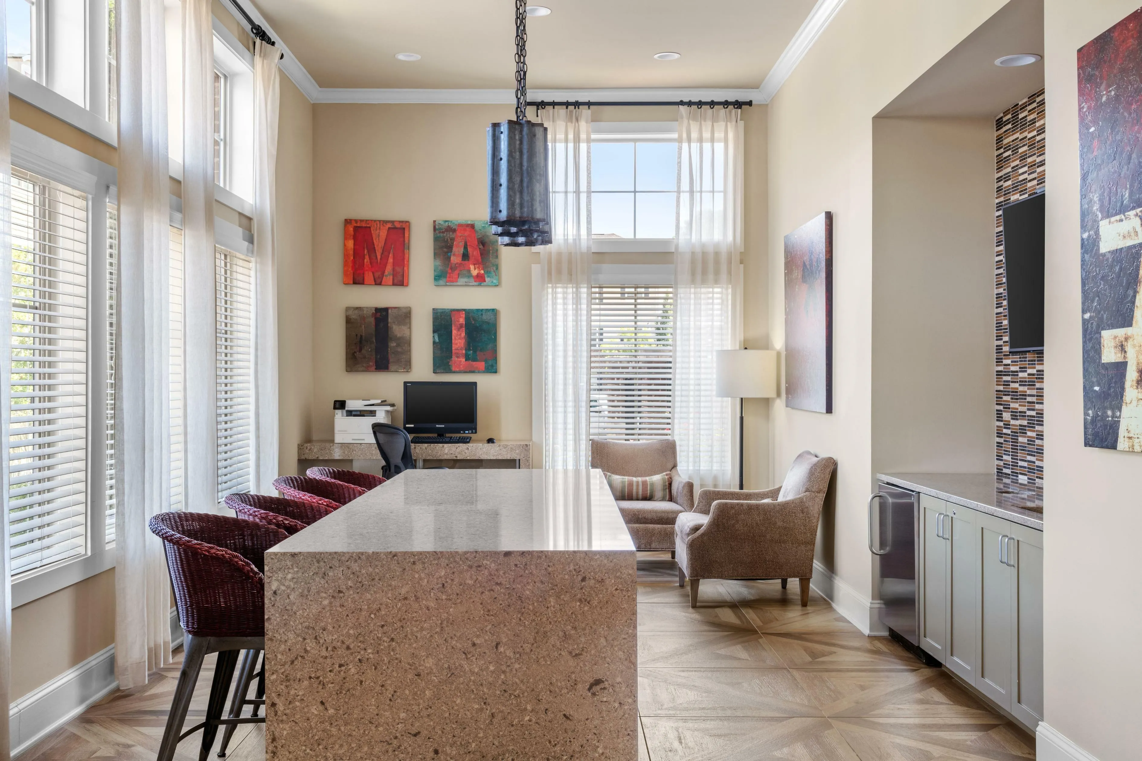 Bright and inviting office space with elegant decor, featuring a sleek granite counter, stylish armchairs, and modern artwork. Perfect for a productive work environment.