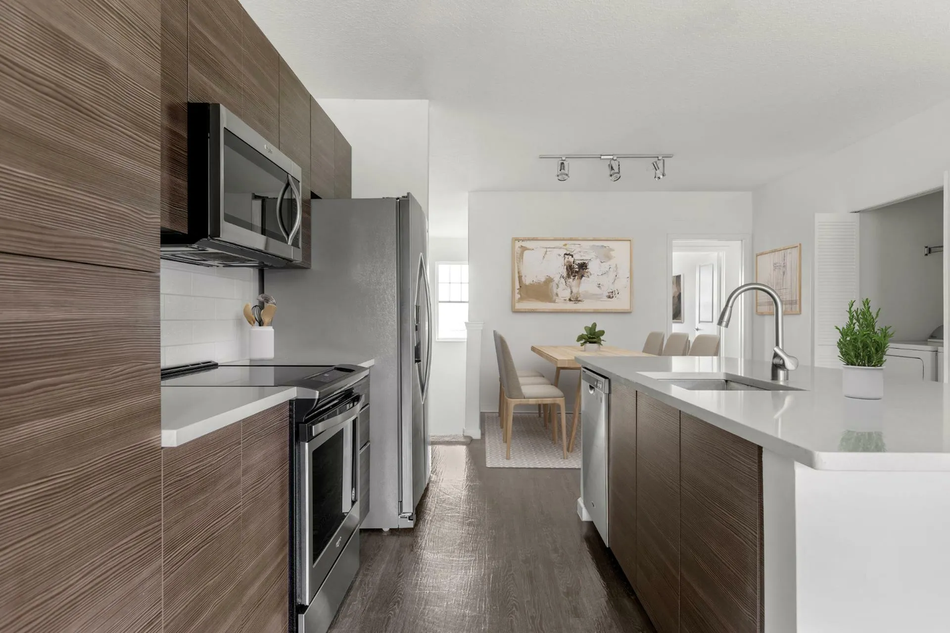 Contemporary open-plan kitchen with sleek appliances and elegant dining area bathed in natural light.