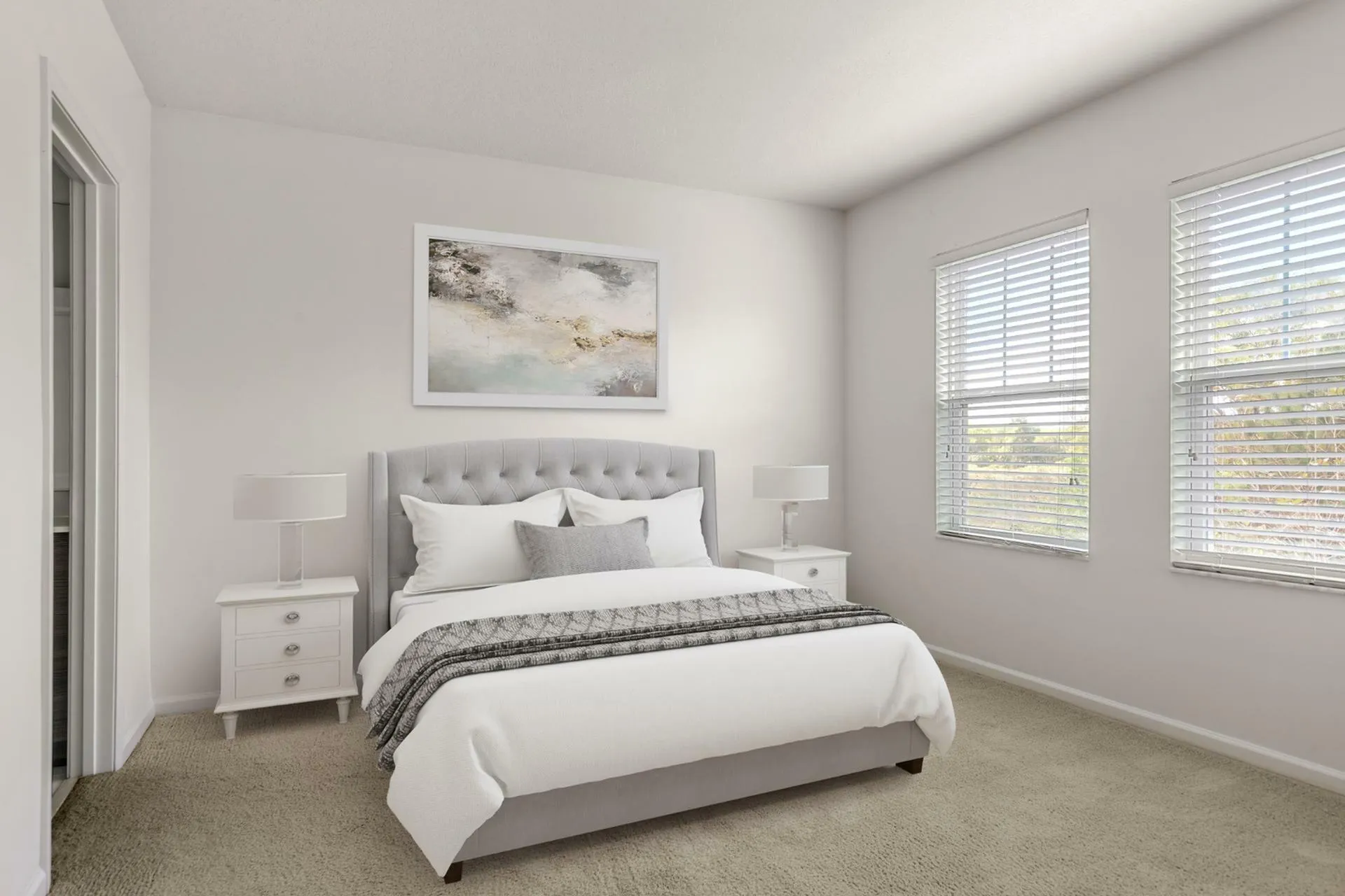 Bright and elegant bedroom featuring a plush gray tufted headboard, modern side tables, and soft natural light streaming through large windows.
