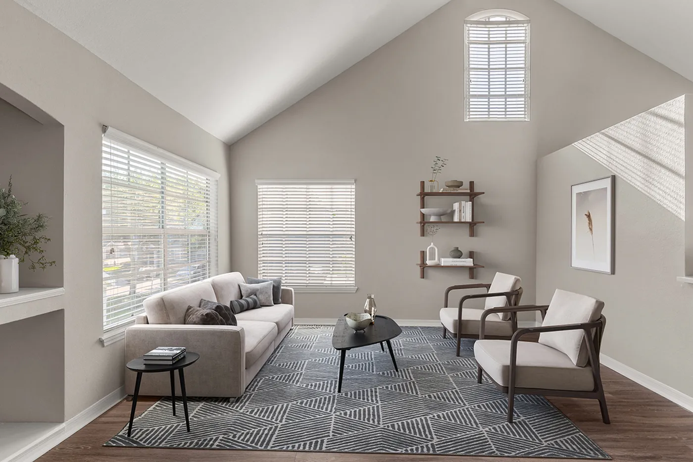 Inviting living room with vaulted ceiling, elegant sofa, stylish armchairs, and modern decor, bathed in natural light.