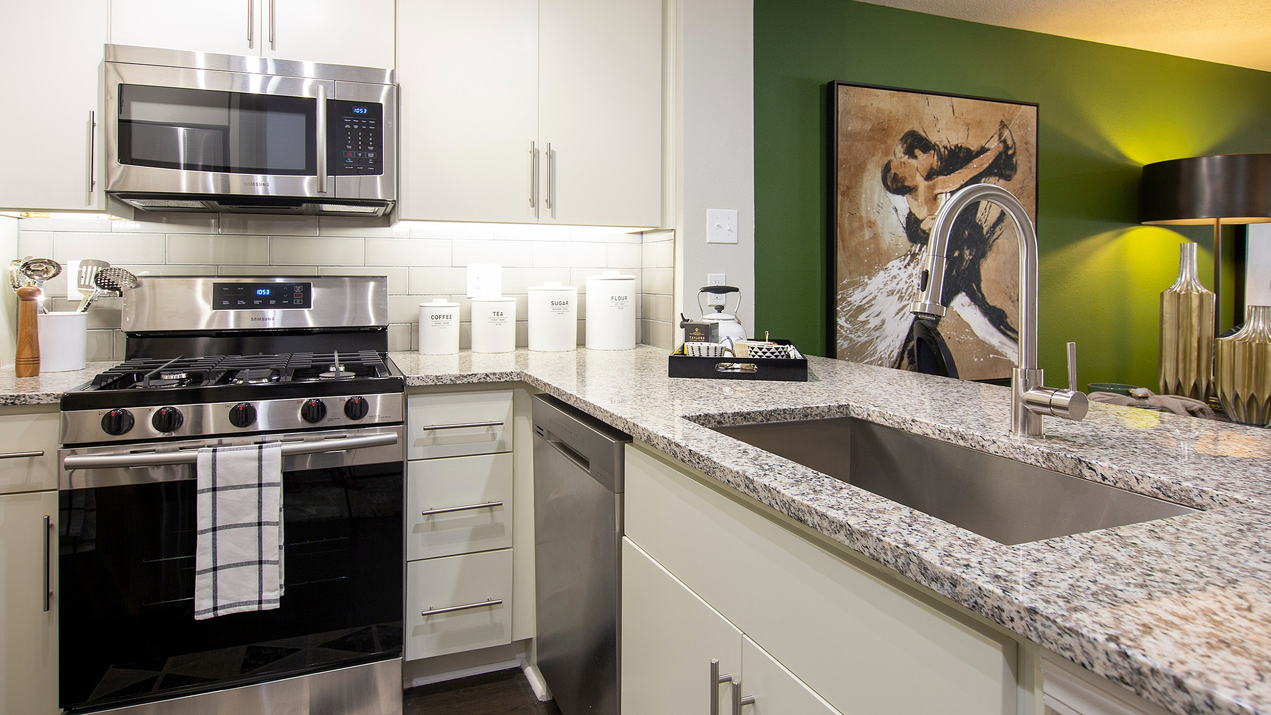 Modern kitchen with stainless steel appliances, elegant granite countertops, and stylish lighting creating a cozy ambiance.