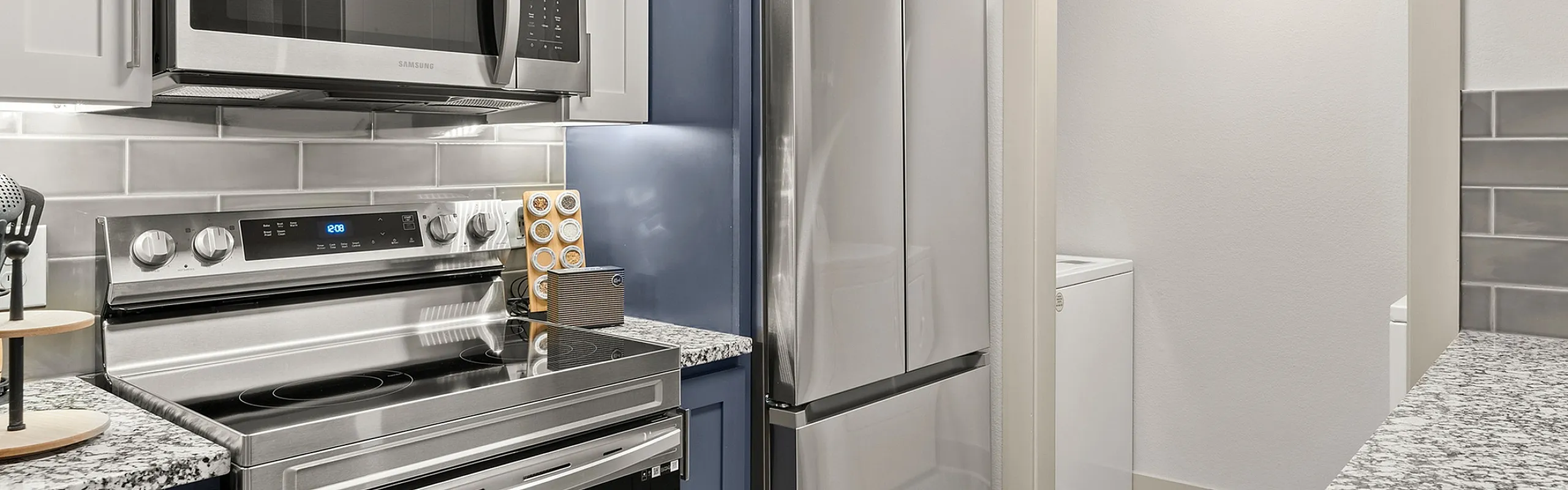Modern kitchen with sleek stainless steel appliances, elegant granite countertops, and stylish backsplash tiles.