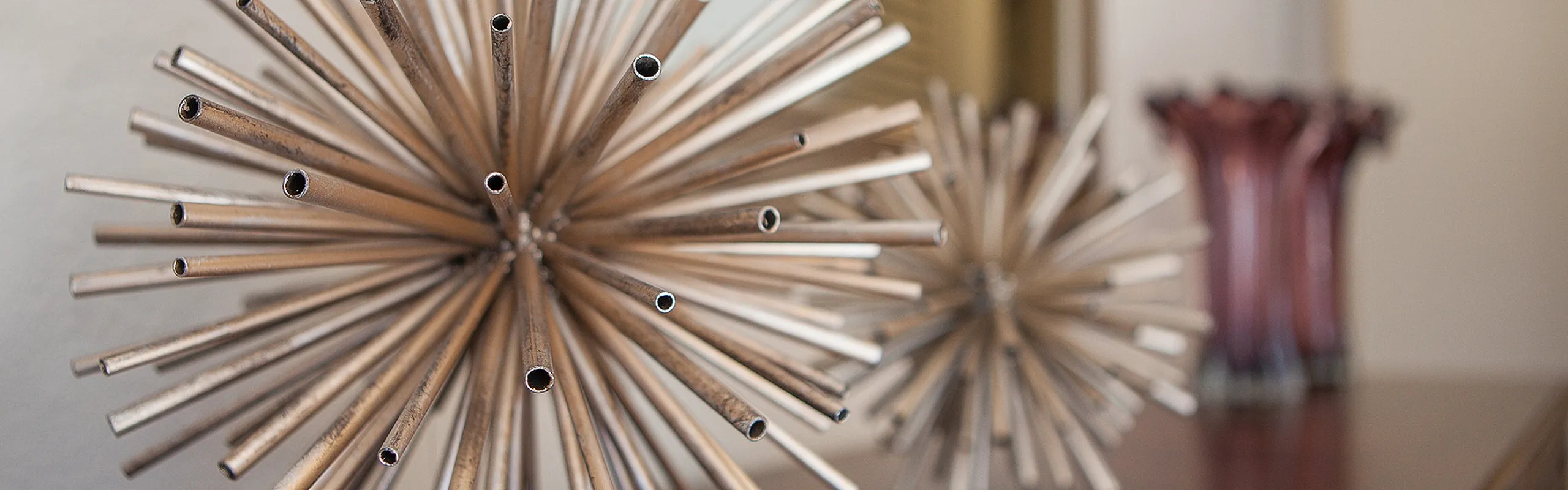 Elegant modern decor with metallic starburst sculptures on a polished wooden surface, enhancing interior style and sophistication.