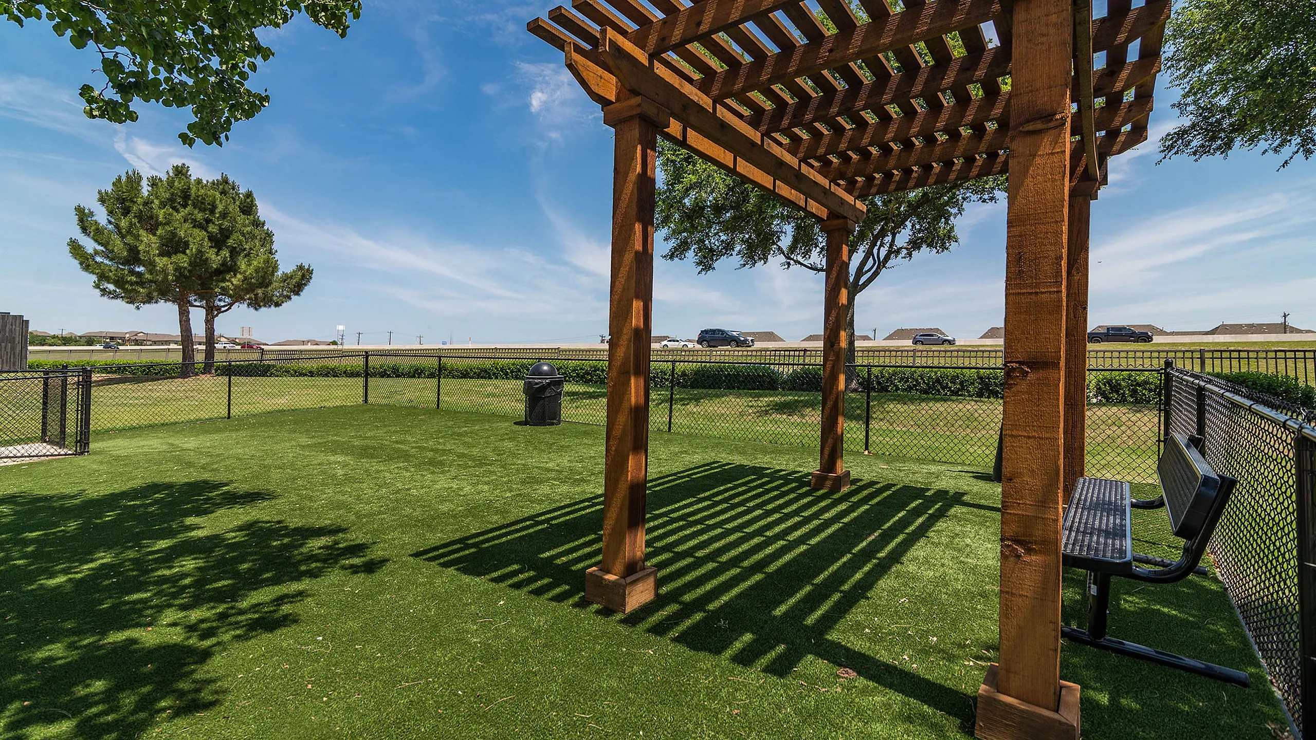Inviting outdoor space featuring a lush green lawn, wooden pergola for shade, and serene seating area with expansive views.