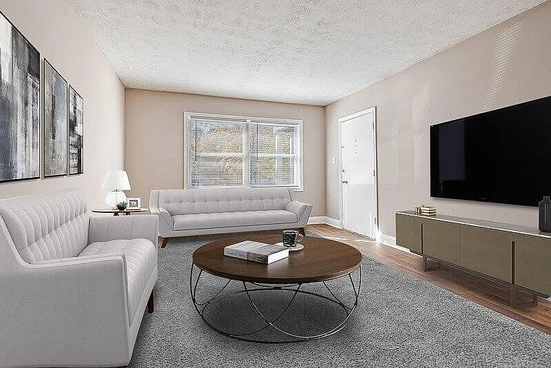 Inviting living room with elegant white sofas, sleek modern furniture, and a large flat-screen TV, perfect for relaxation and entertainment.