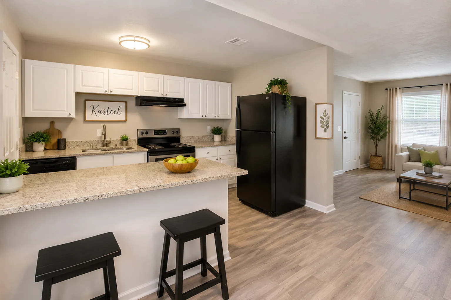 Inviting open-plan kitchen and living area featuring modern decor, sleek black appliances, and abundant natural light.