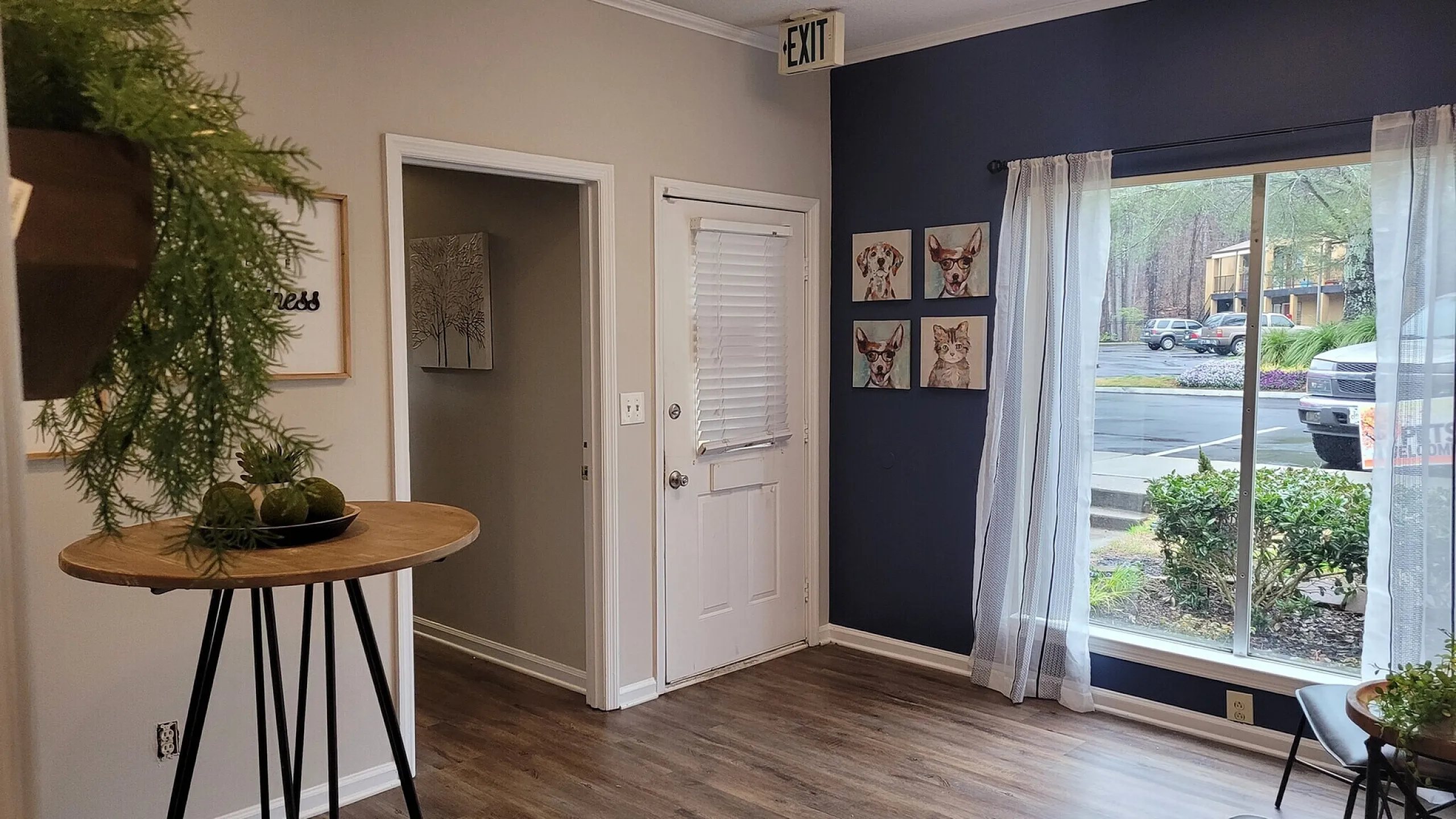 Charming apartment entryway with stylish decor, natural light streaming through large windows, and modern hardwood flooring.