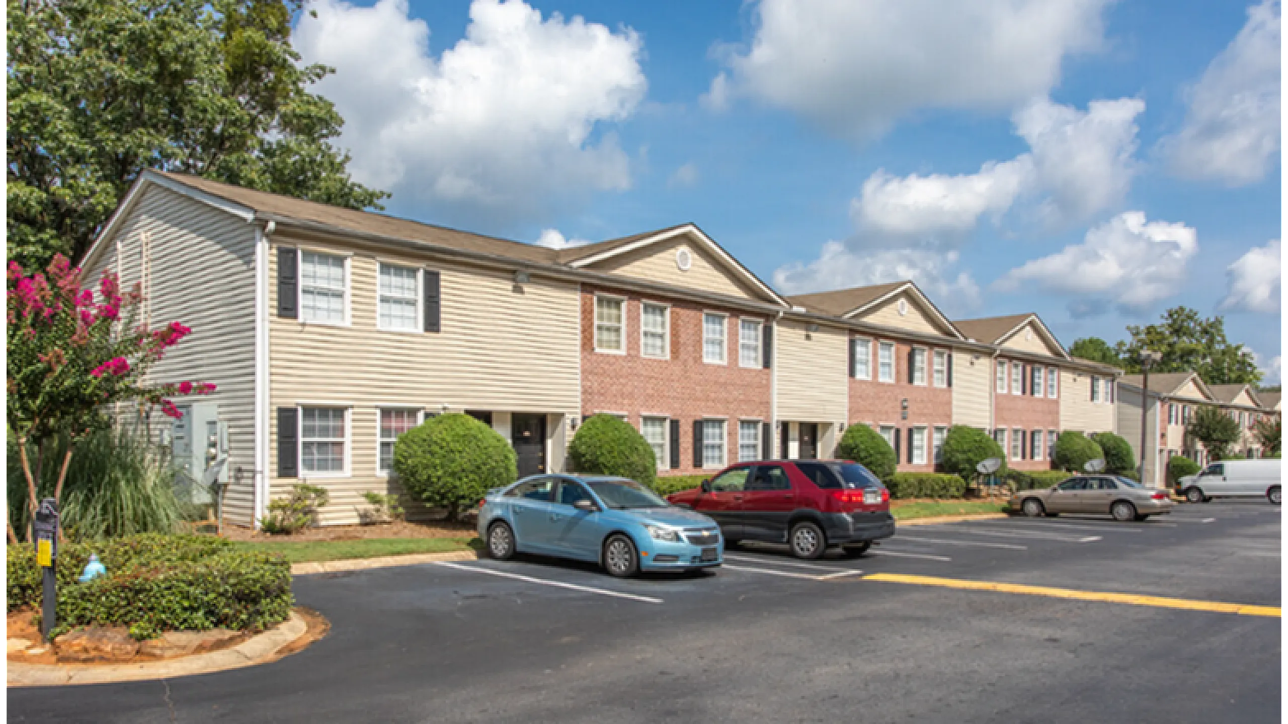 Charming townhouse community with well-maintained landscaping, featuring ample parking and a vibrant suburban atmosphere.