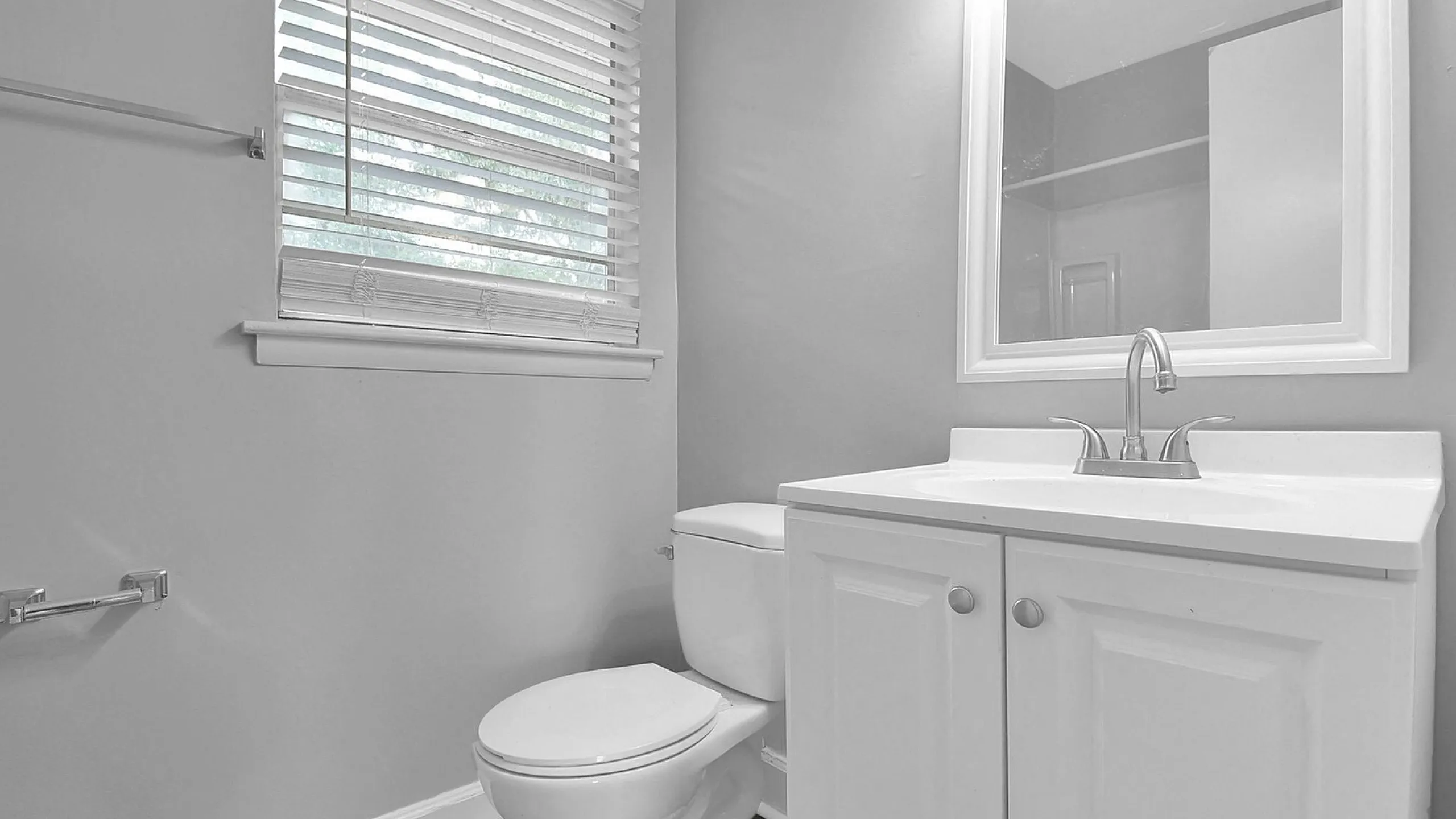 Elegant bathroom with modern fixtures, featuring a sleek white vanity, stylish tap, and a spacious mirror.
