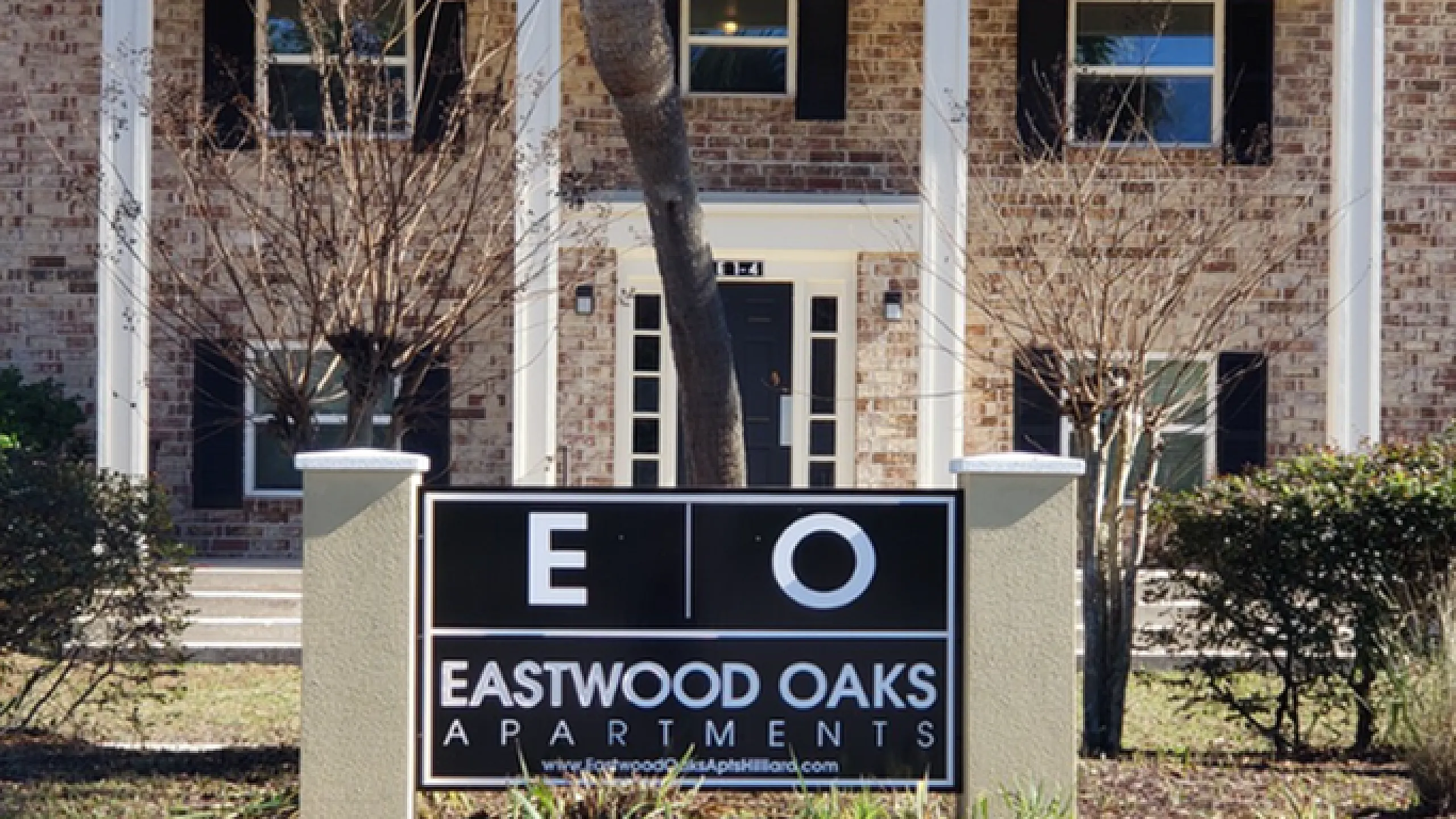 Welcoming entrance to Eastwood Oaks Apartments with classic brick architecture and manicured surroundings.
