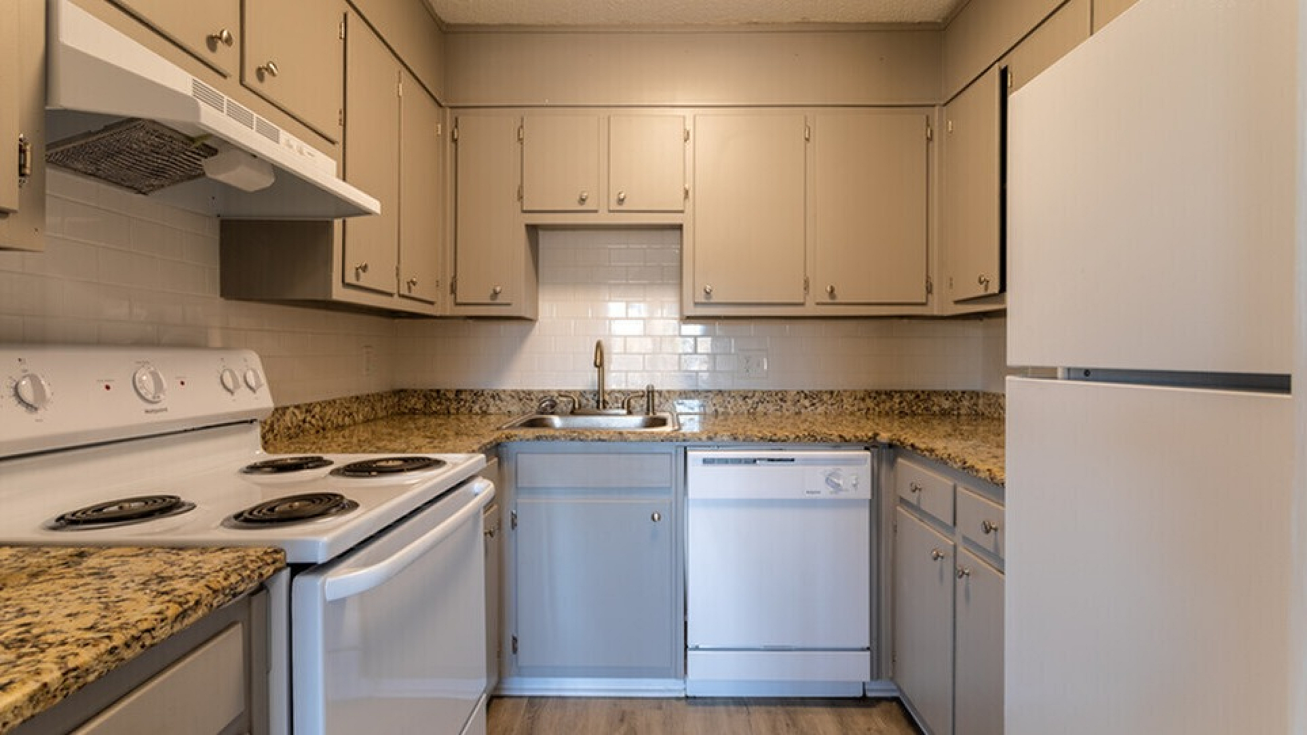 Cozy kitchen with modern appliances, granite countertops, and ample cabinetry in a sleek, neutral design.
