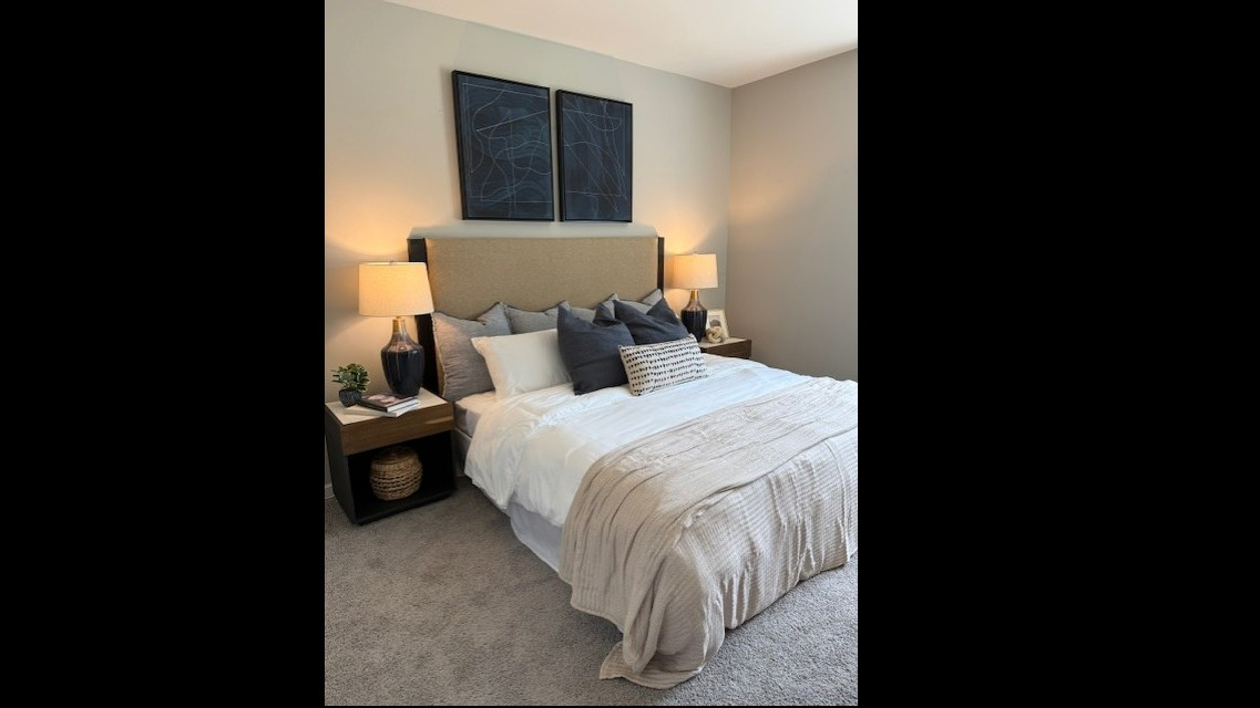 Elegant bedroom with a plush bed, modern decor, and cozy ambiance, featuring stylish lamps and artistic wall frames.