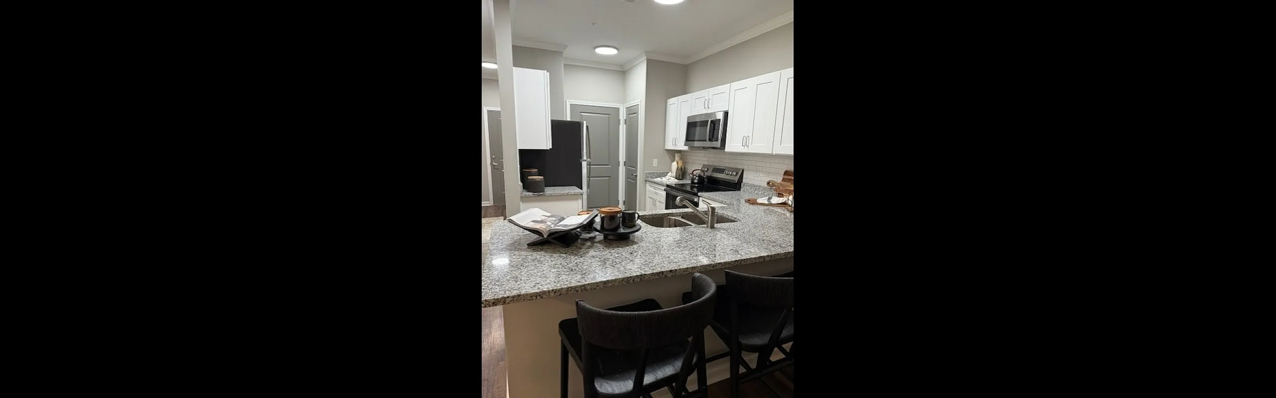 Modern kitchen with sleek countertops, contemporary appliances, and stylish bar seating, creating an inviting space for cooking and entertaining.