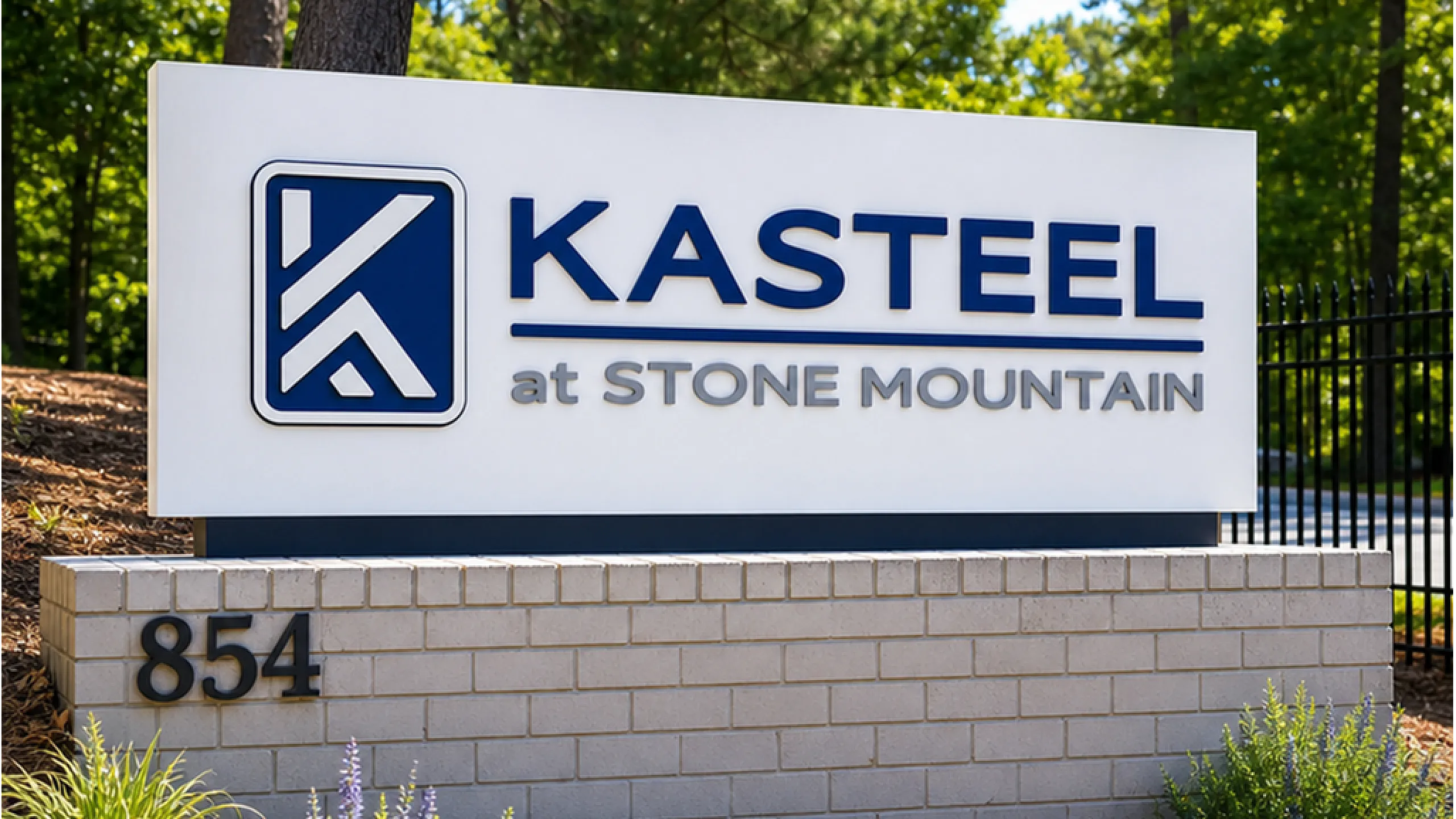 Inviting sign for Kasteel at Stone Mountain, surrounded by lush greenery and elegant landscaping.
