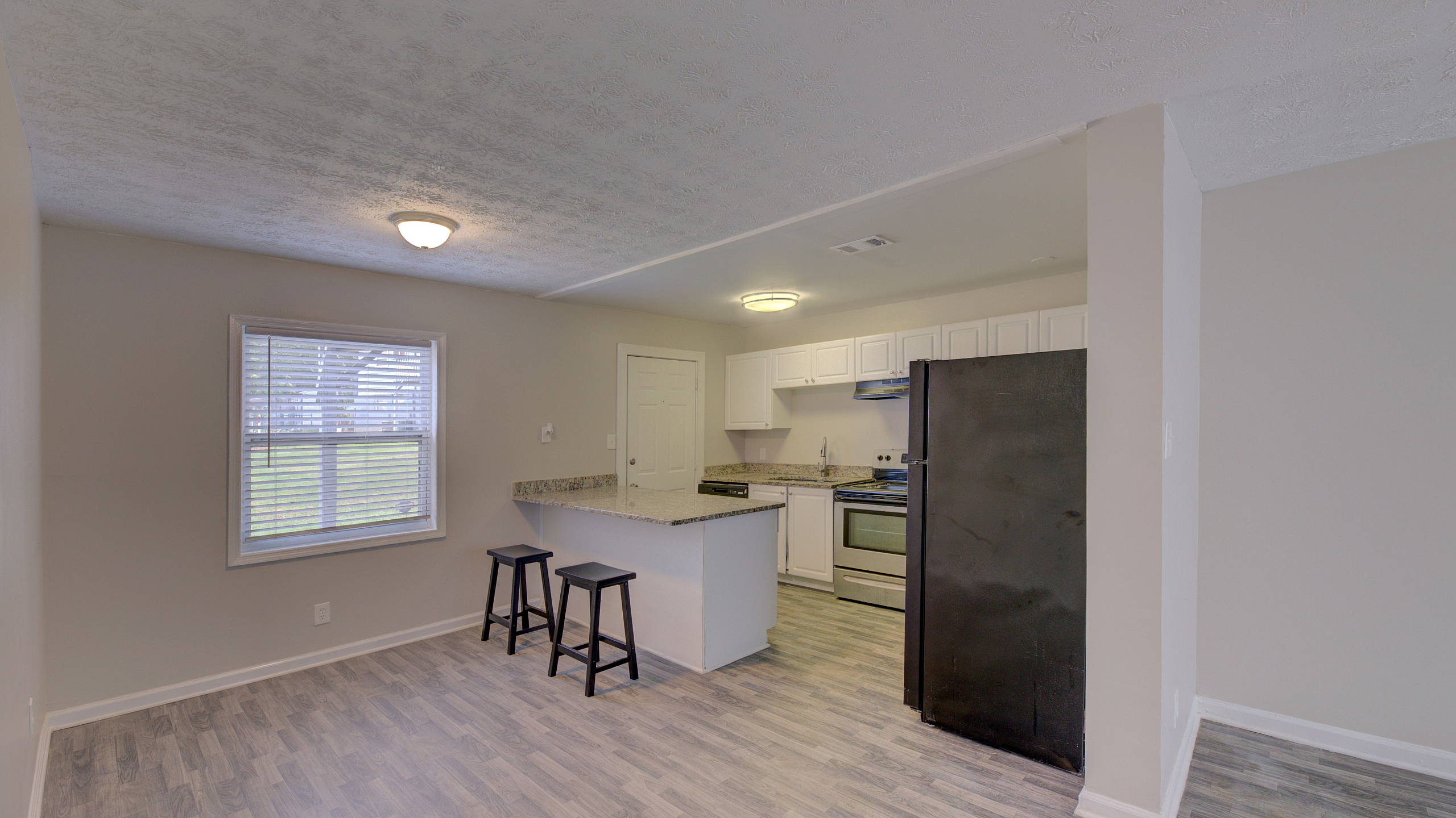 Bright and inviting kitchen with modern appliances, sleek countertops, and bar seating in an open layout.