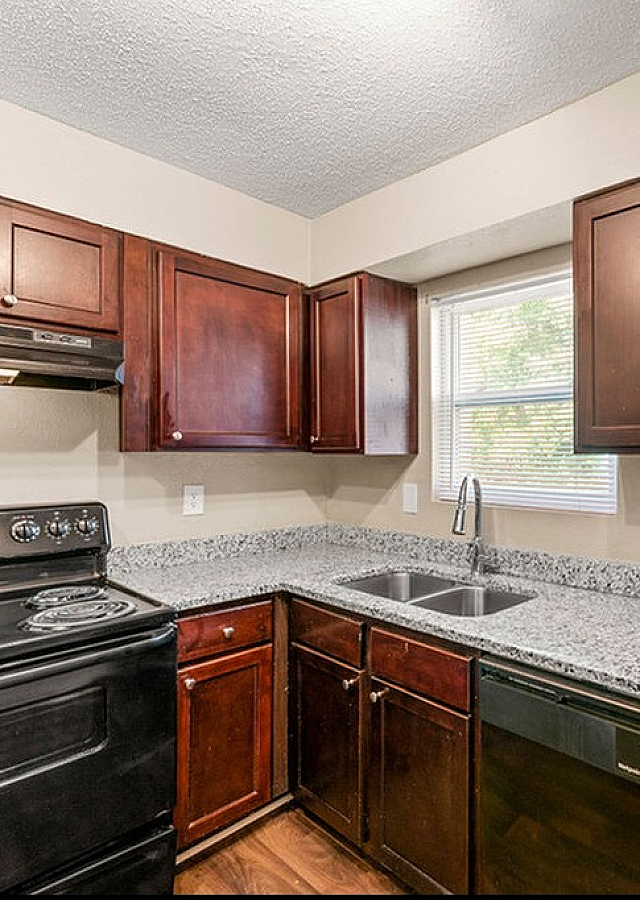 Charming kitchen with sleek granite countertops, elegant dark wood cabinets, and modern appliances for a stylish touch.