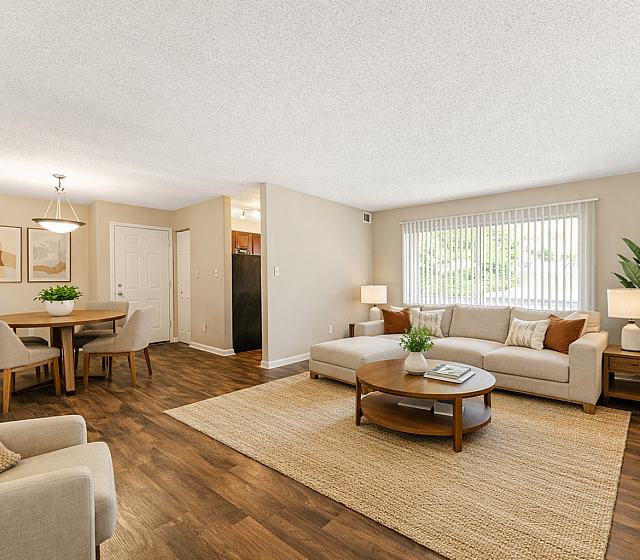 Bright and inviting living room with elegant decor, cozy seating area, and natural light from large windows creating a warm atmosphere.
