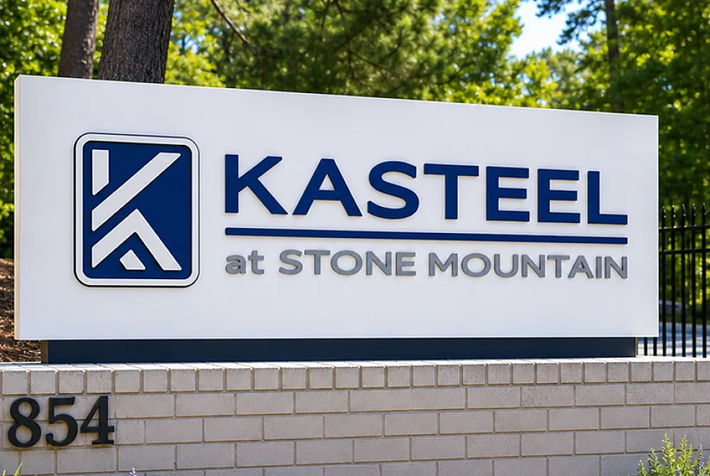 Inviting entrance sign of Kasteel at Stone Mountain surrounded by lush greenery, offering a serene and welcoming atmosphere.
