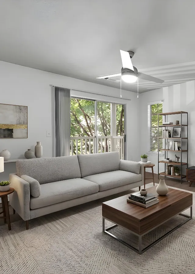 Chic and cozy living room with a modern gray sofa, elegant coffee table, and abundant natural light from a balcony view.