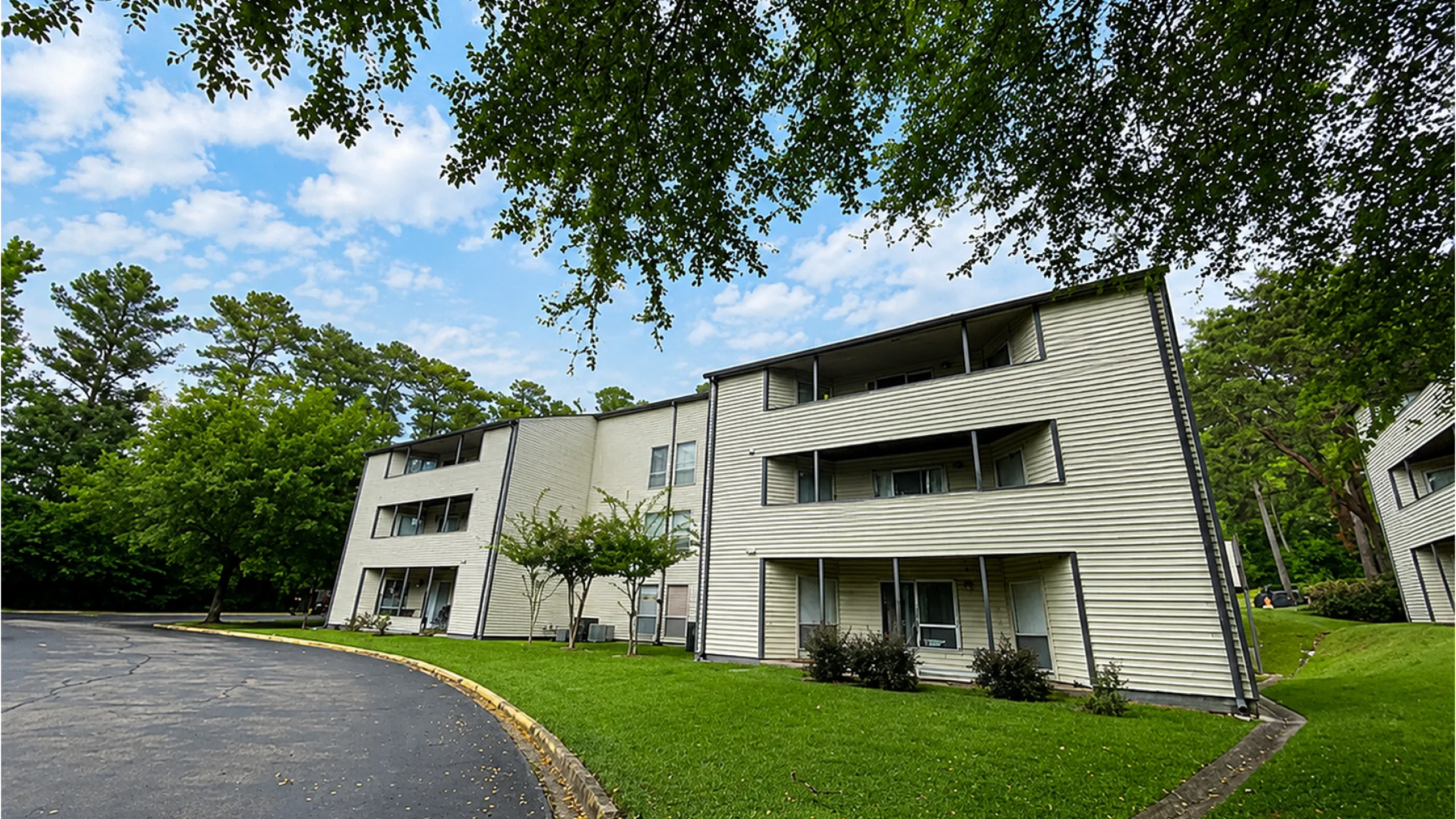 Charming apartment complex nestled in lush greenery, offering serene living with spacious balconies and modern design.
