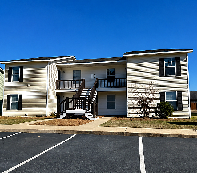 Charming two-story apartment building with inviting front stairs and well-maintained landscaping, perfect for a cozy and convenient living experience.