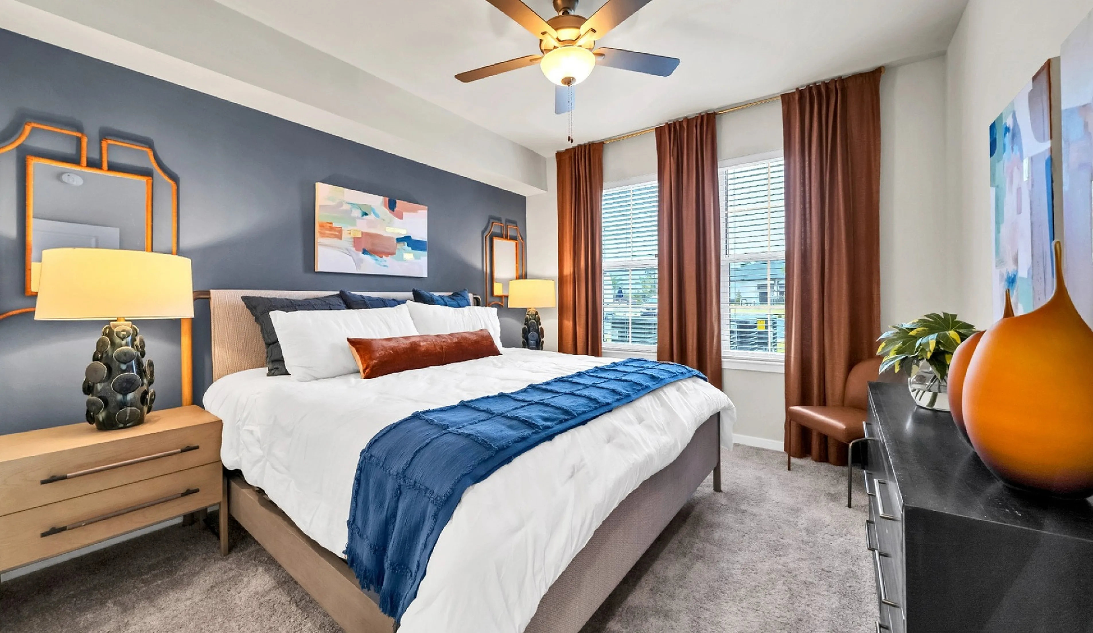 Inviting bedroom featuring elegant decor, a cozy bed with plush pillows, and abundant natural light through large windows.