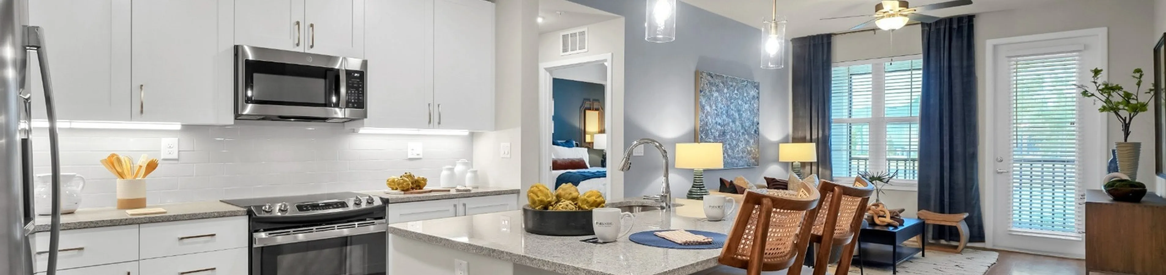 Bright and modern open-concept kitchen and living area featuring sleek white cabinetry and elegant wooden floors.