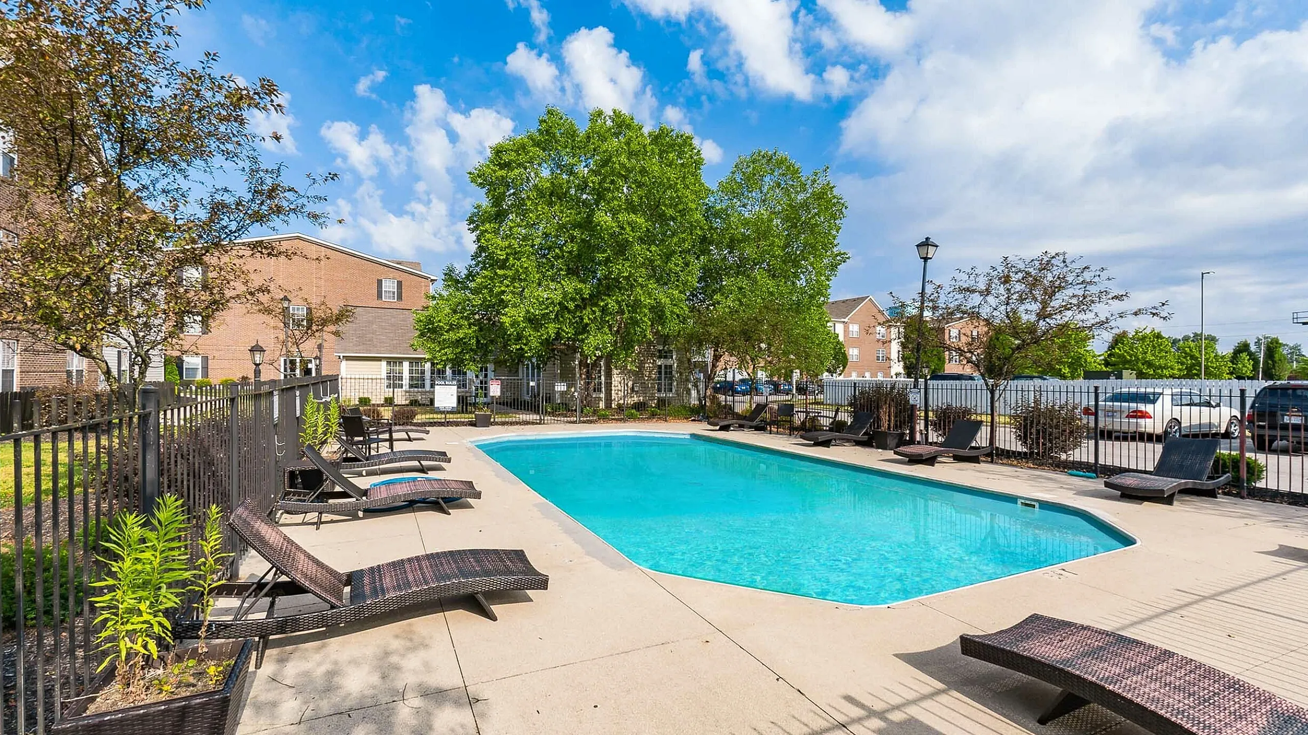 Inviting outdoor pool area with stylish lounge chairs under a clear blue sky.